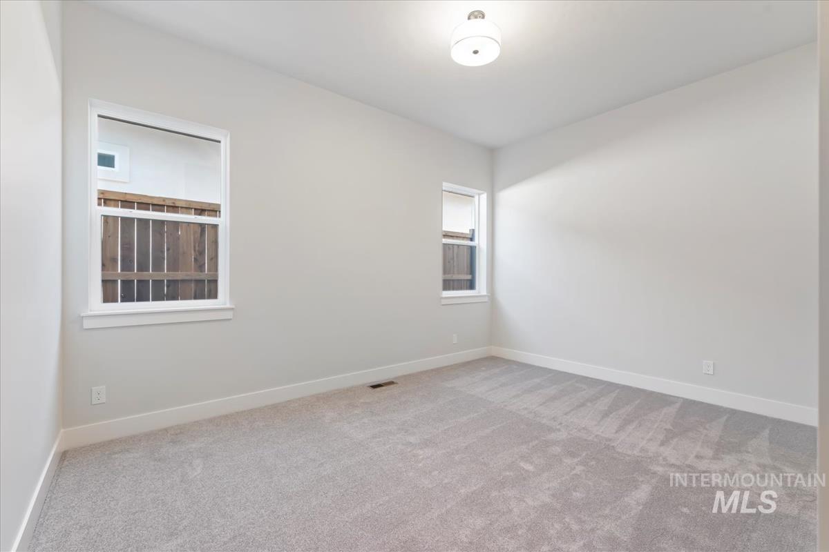 Spare room featuring carpet and baseboards