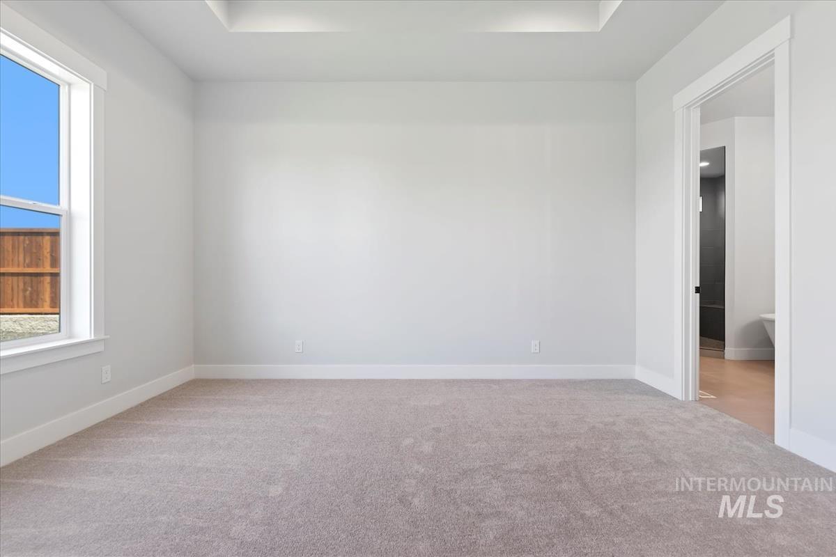 Empty room with light carpet and baseboards