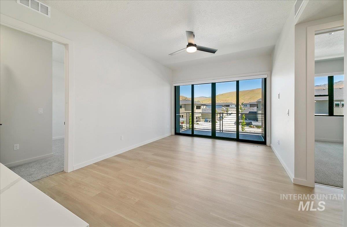 Spare room featuring a textured ceiling, light wood finished floors, and a ceiling fan