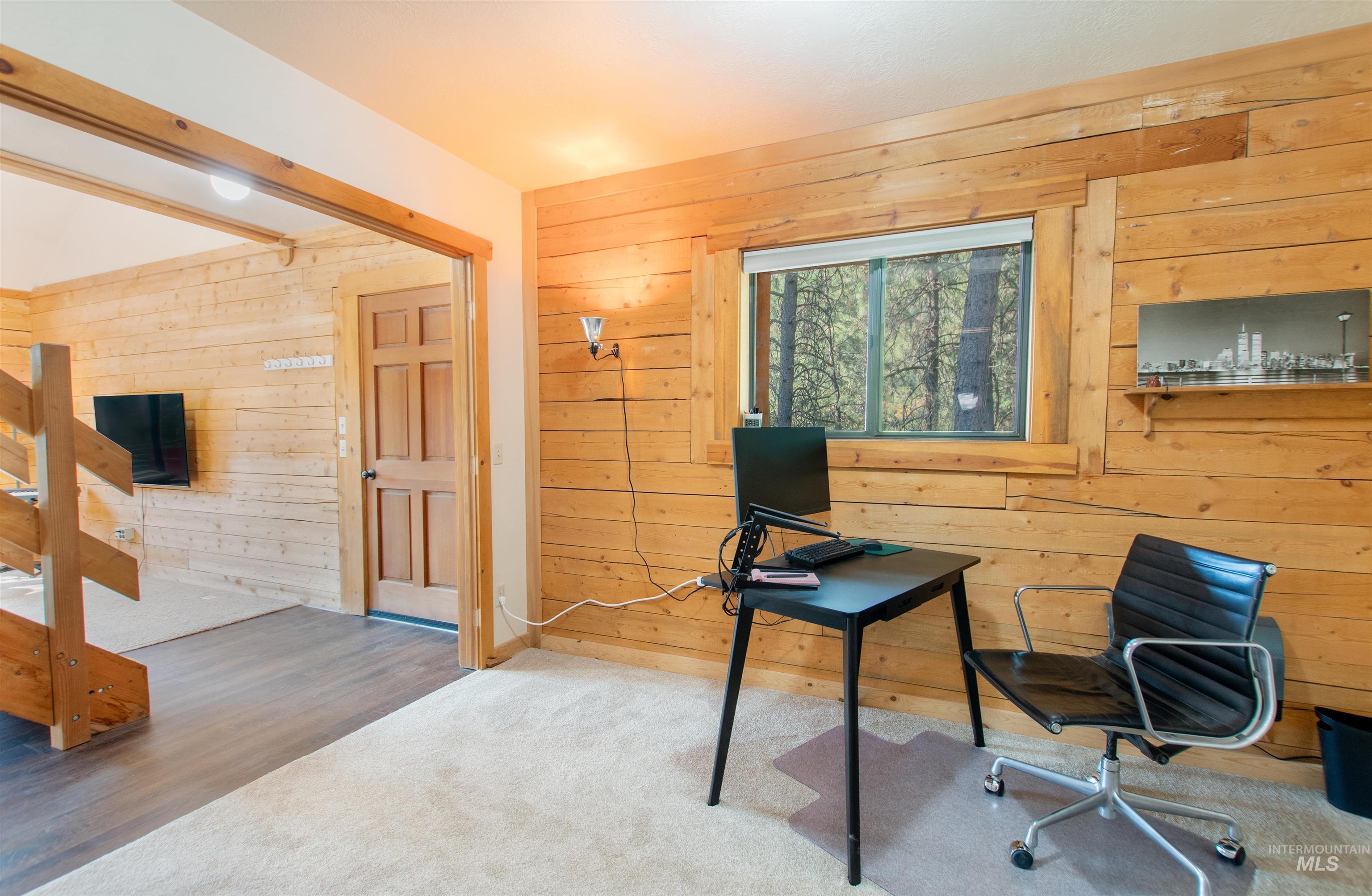 Carpeted office with wooden walls