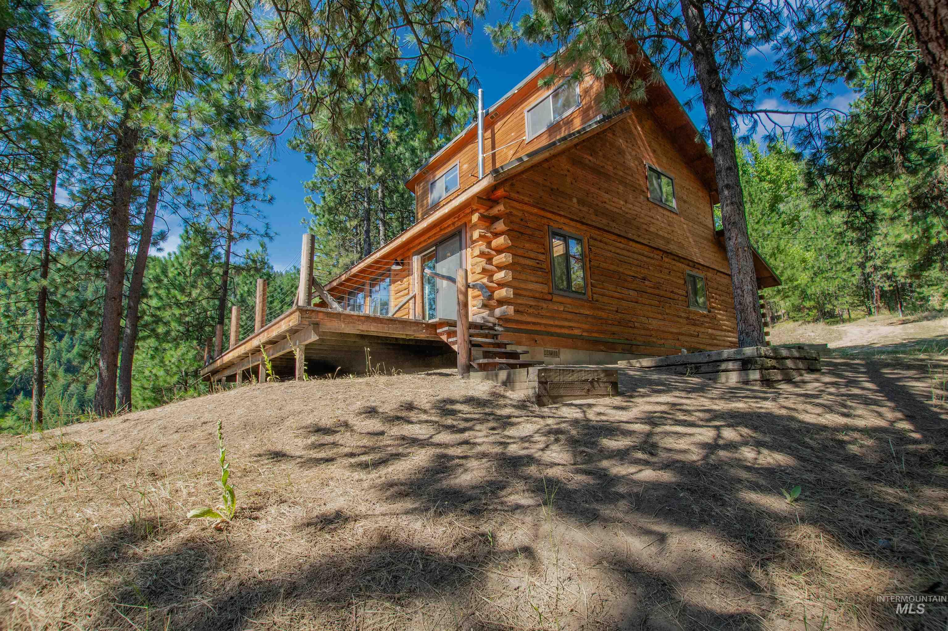 View of side of property with log exterior and a wooden deck