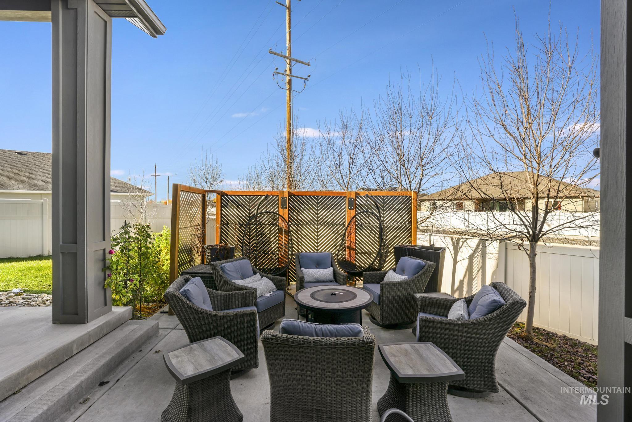 Fenced backyard with a patio area and an outdoor living space with a fire pit