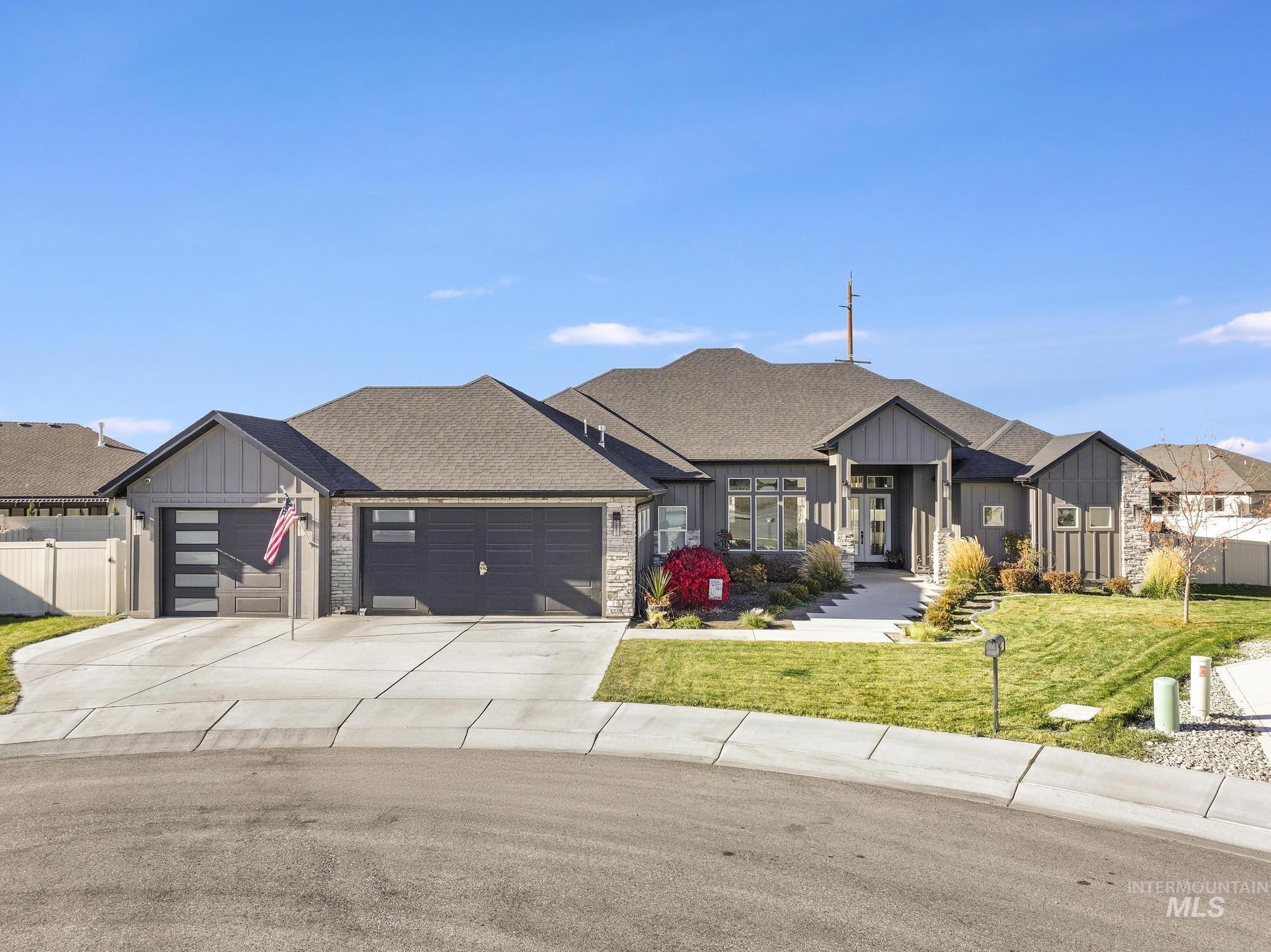 Modern inspired farmhouse featuring board and batten siding, concrete driveway, a shingled roof, a garage, and stone siding