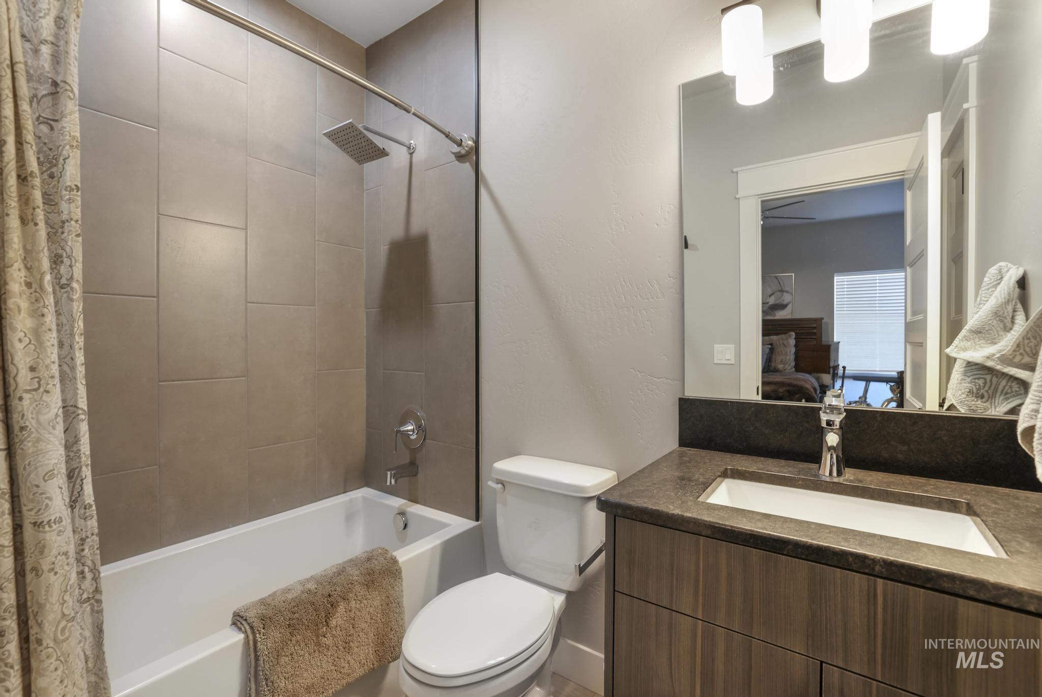 Ensuite bathroom featuring vanity and shower / bath combination with curtain
