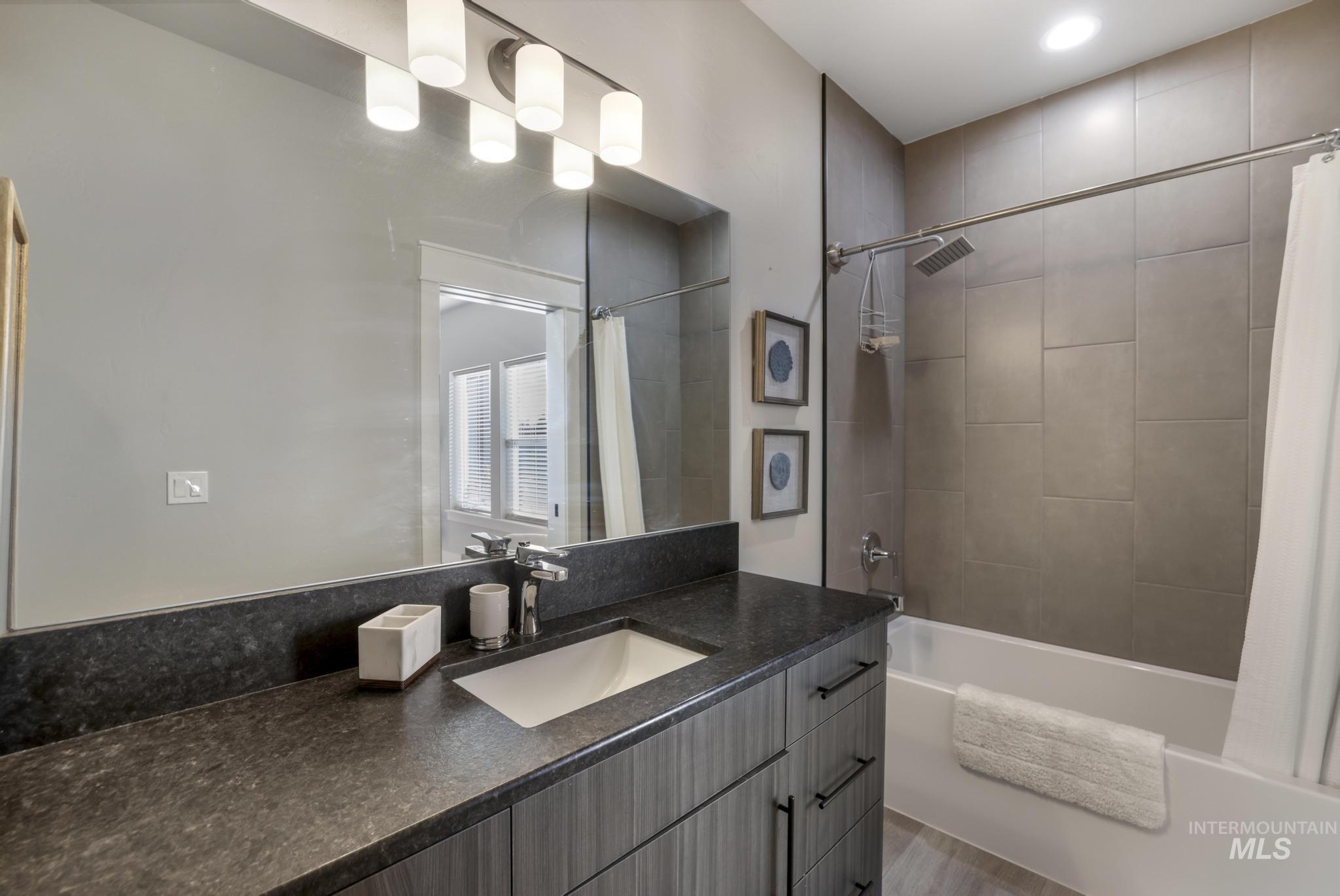 Full bathroom with shower / tub combo and vanity