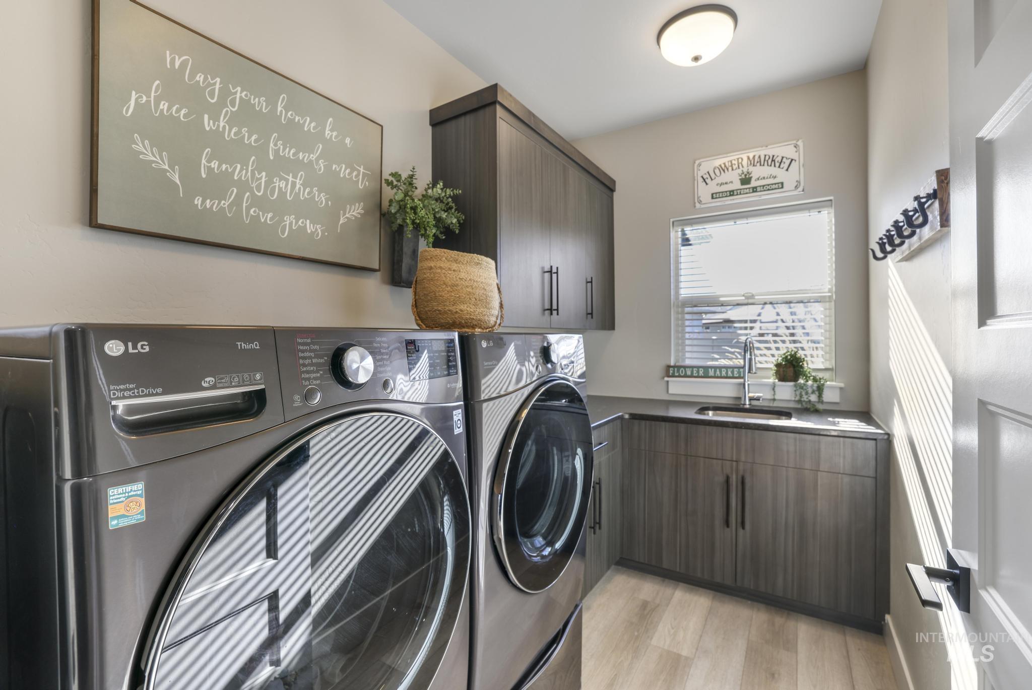 Washroom featuring cabinet space, light wood finished floors, and washing machine and dryer