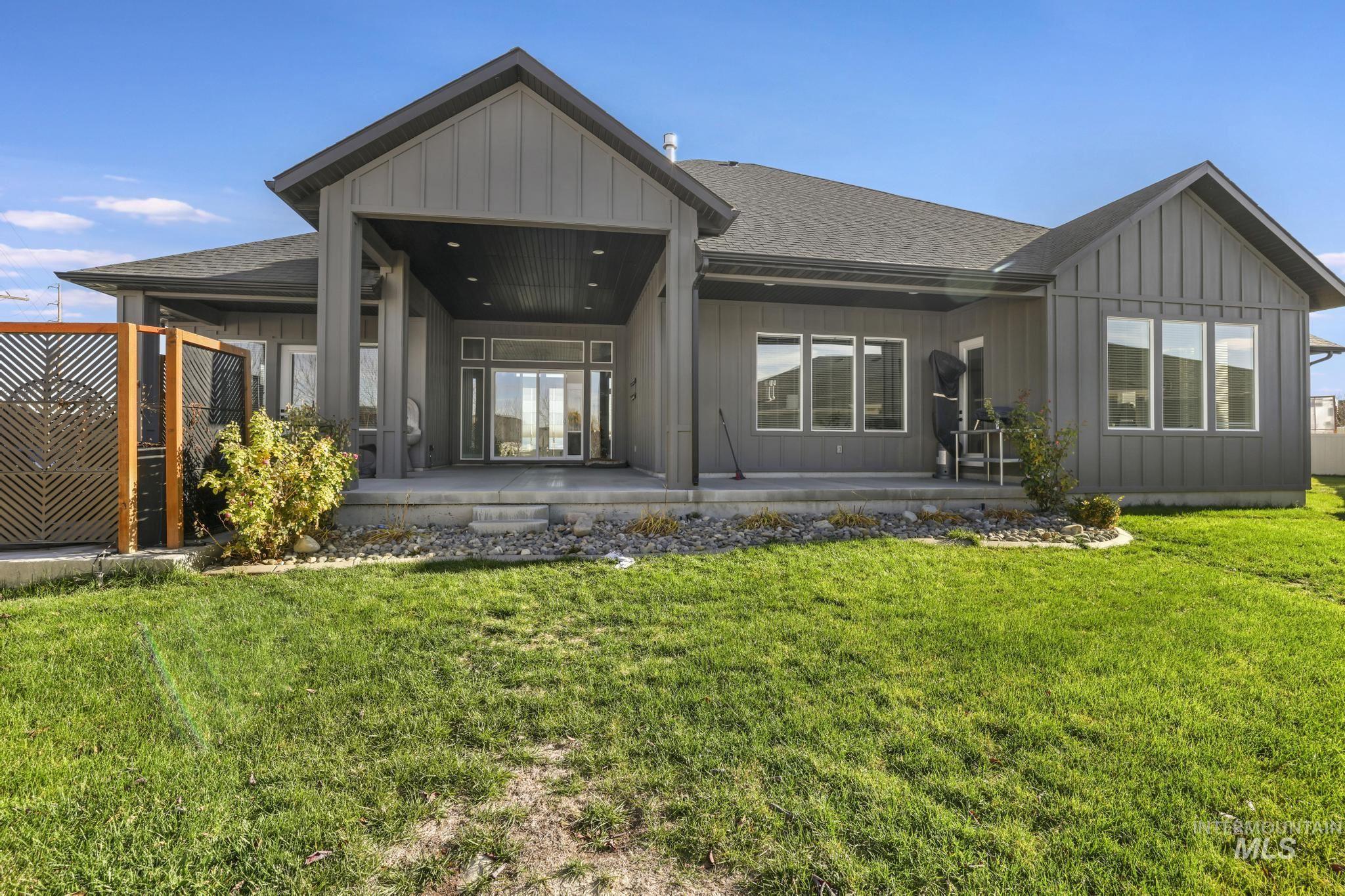 Back of property with roof with shingles, board and batten siding, a patio area, and french doors