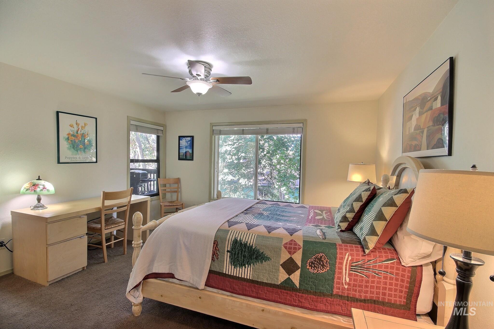 Bedroom with carpet floors, a ceiling fan, an office area, and access to outside
