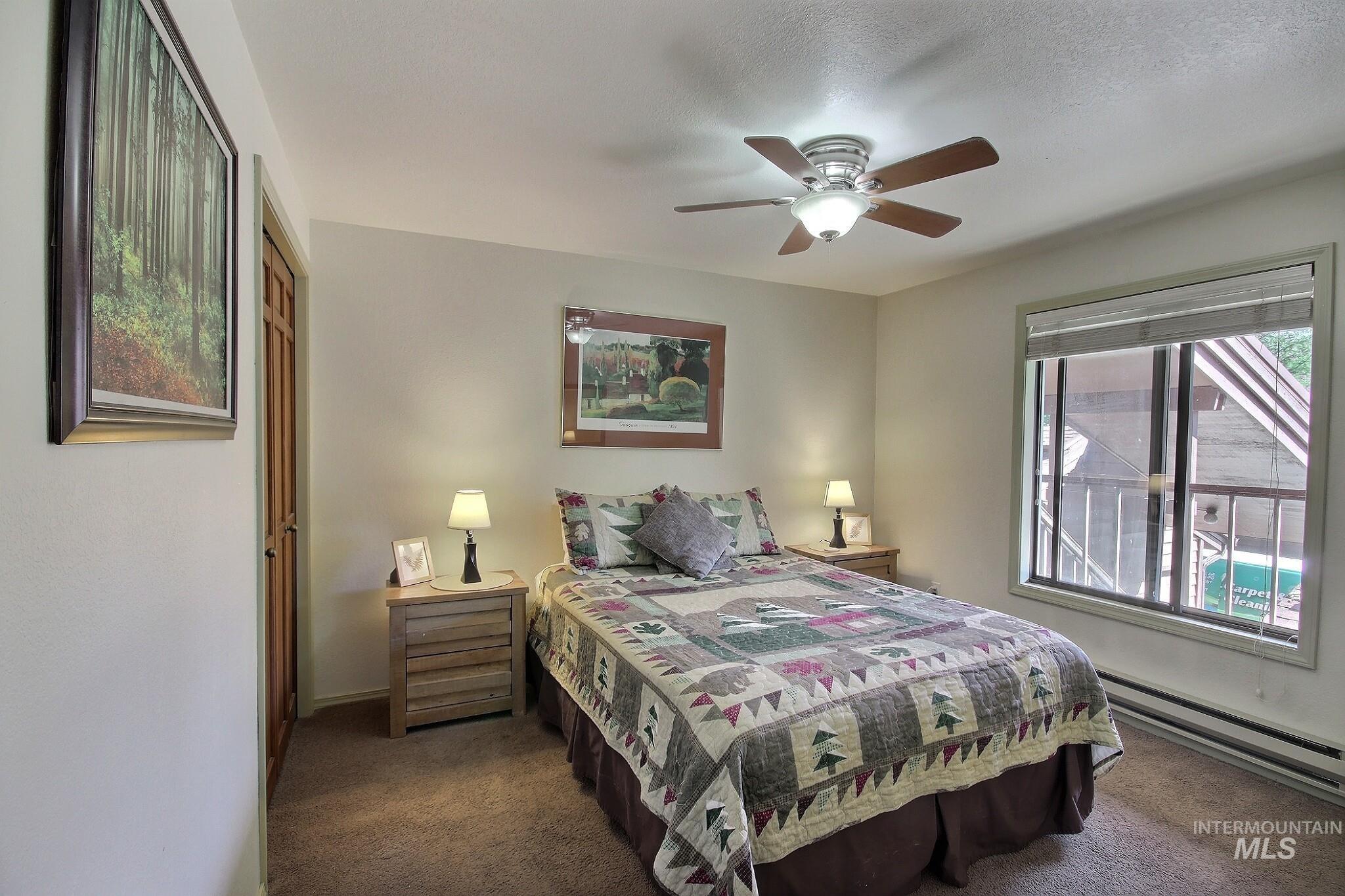 Bedroom featuring a baseboard radiator, carpet floors, and a ceiling fan
