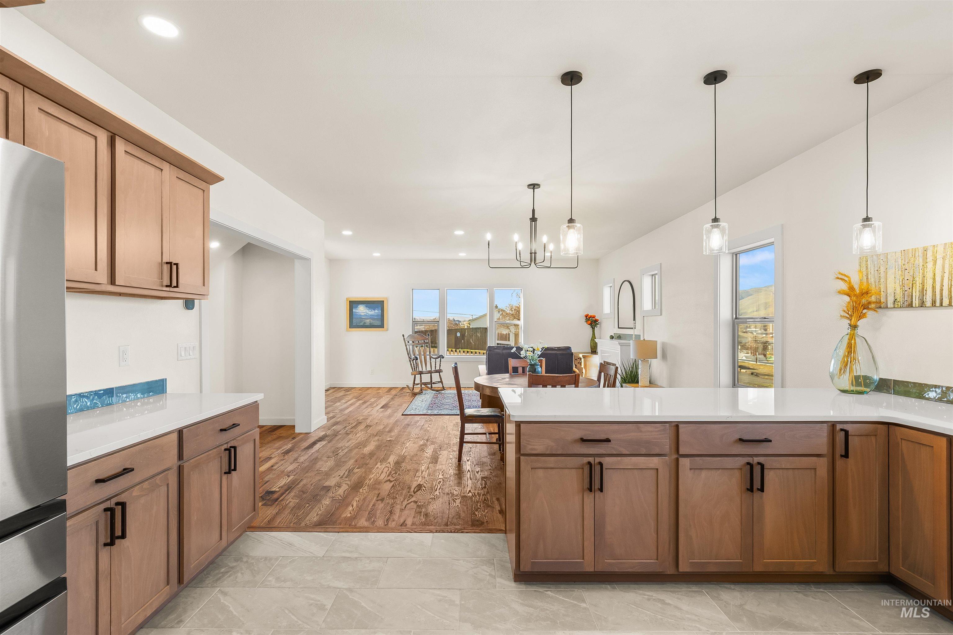 Kitchen with freestanding refrigerator, wood finish cabinetry, and a peninsula