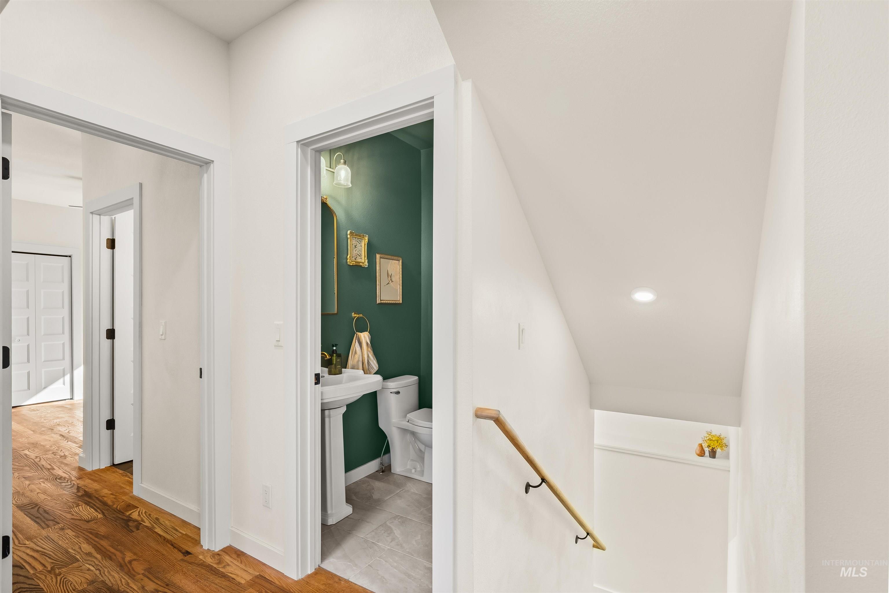 Hallway featuring light wood-style flooring and an upstairs landing