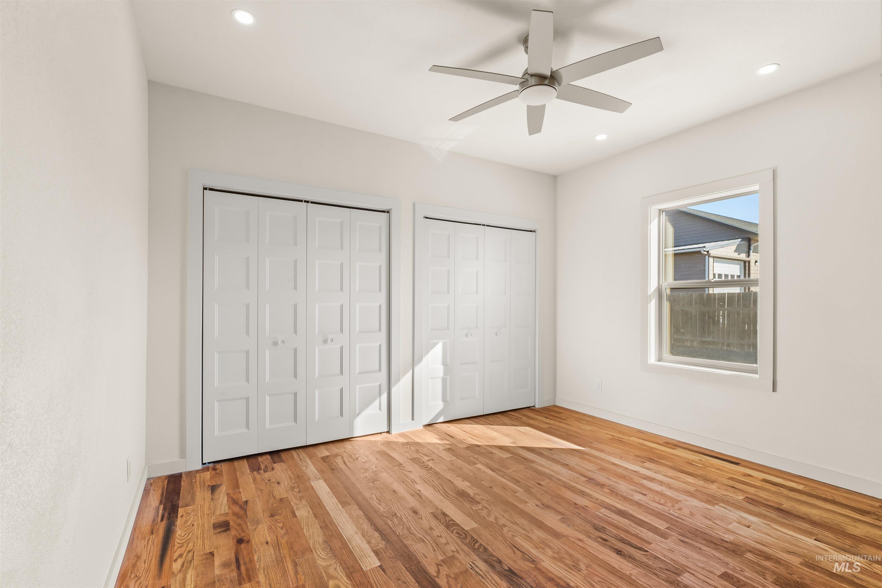Unfurnished bedroom with multiple closets, light wood-type flooring, ceiling fan, and recessed lighting