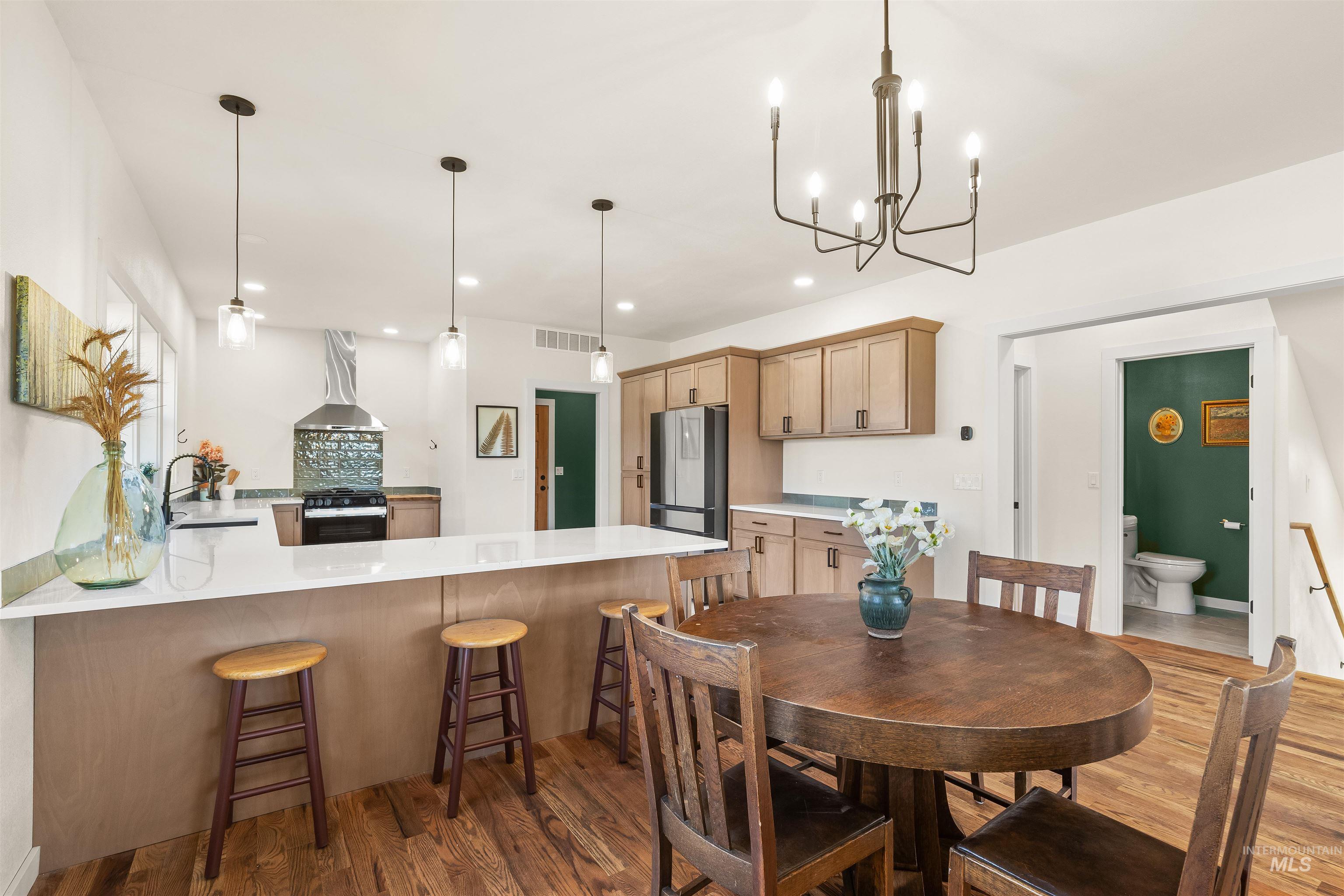 Dining area with dark wood-type flooring and hanging lights