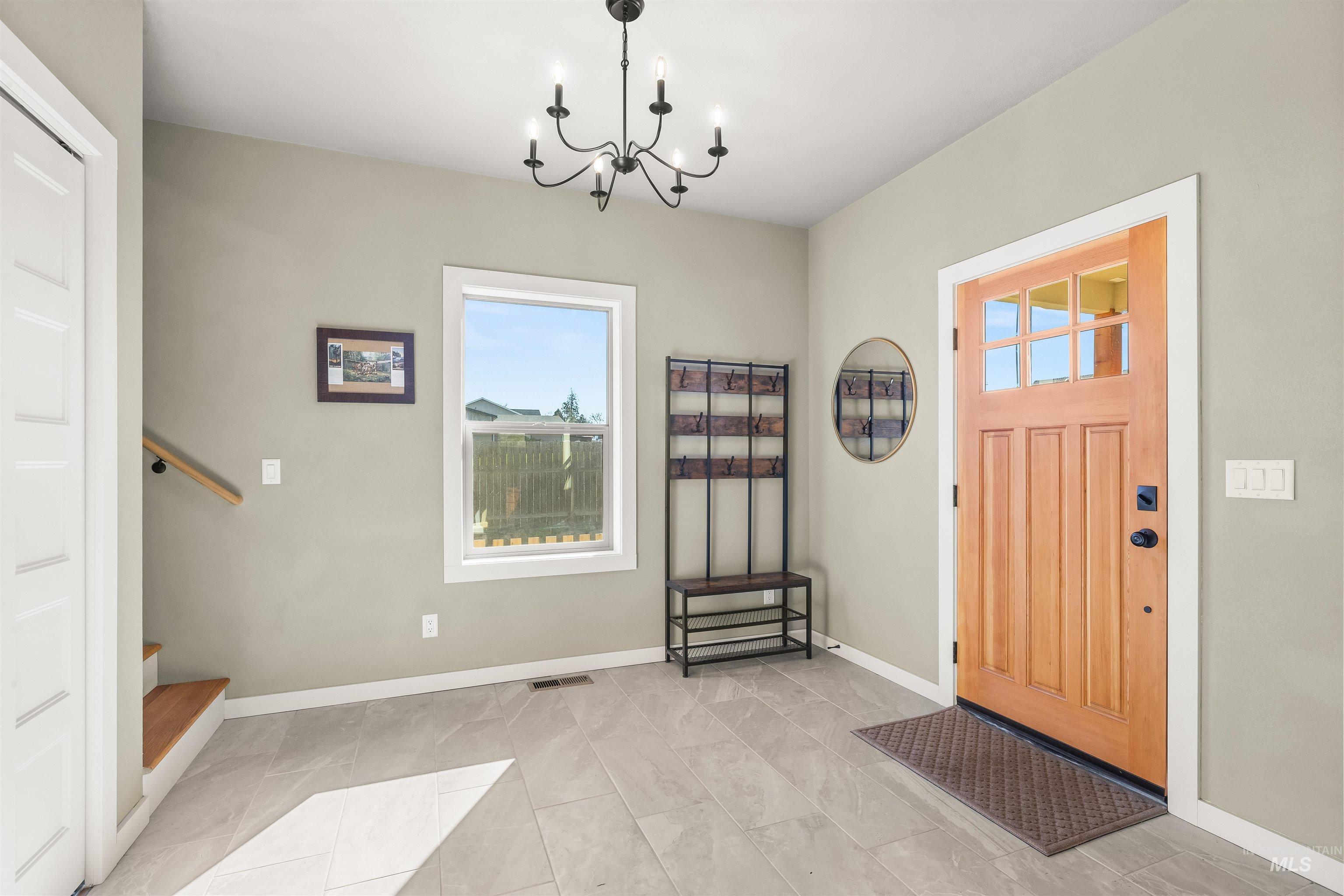 Foyer with stairway and suspended lighting
