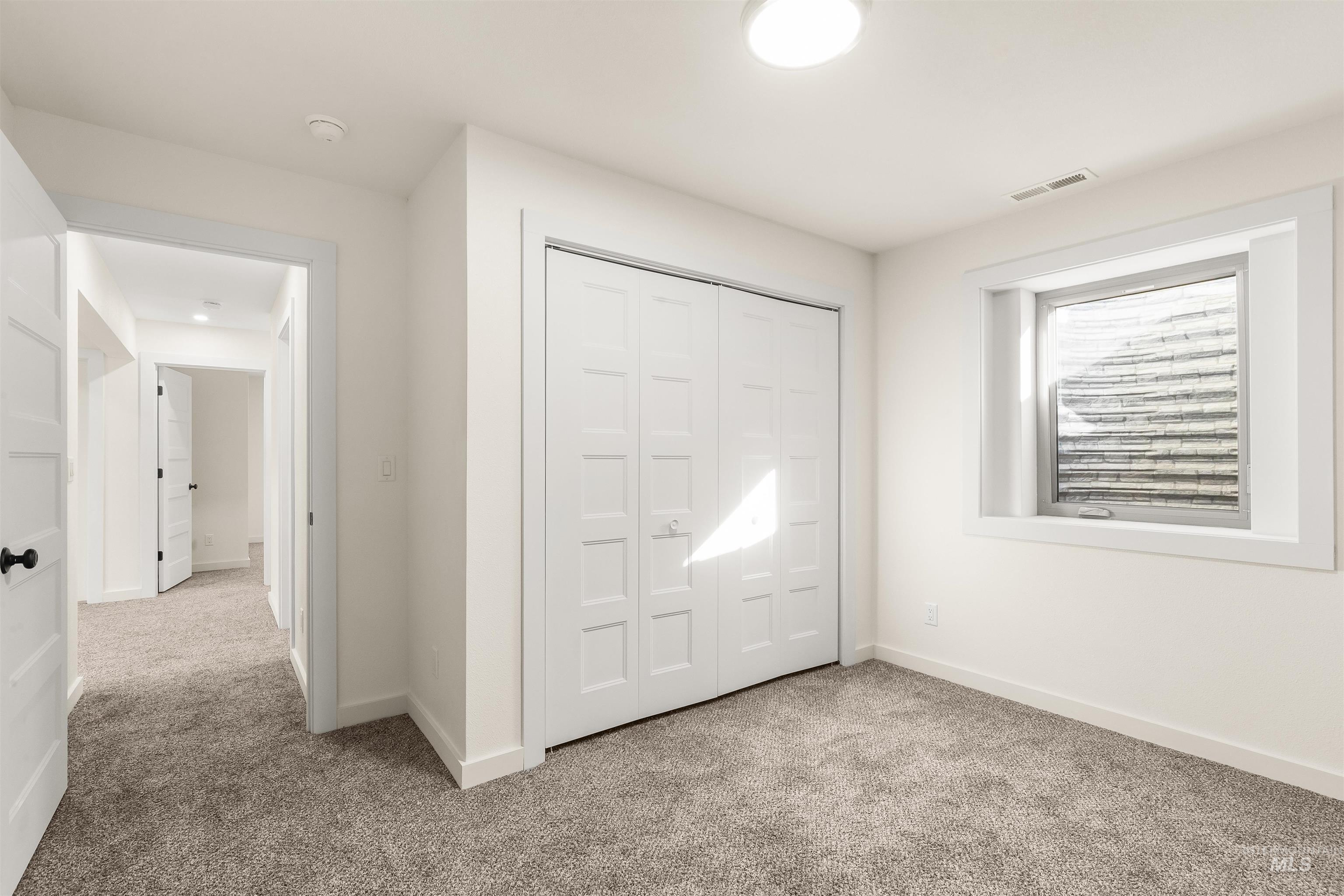 Unfurnished bedroom with light carpet and a closet