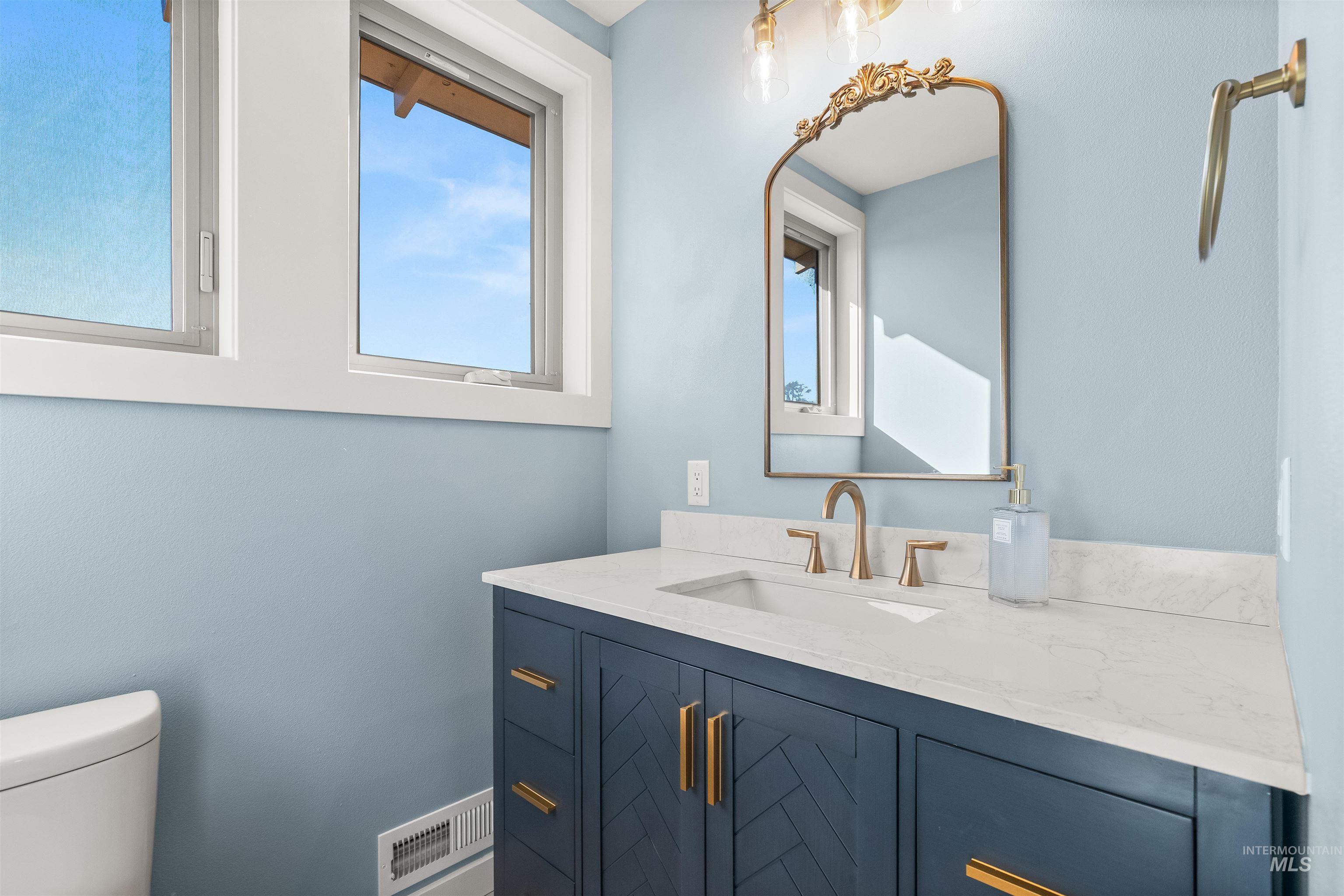 Half bathroom featuring vanity and healthy amount of natural light