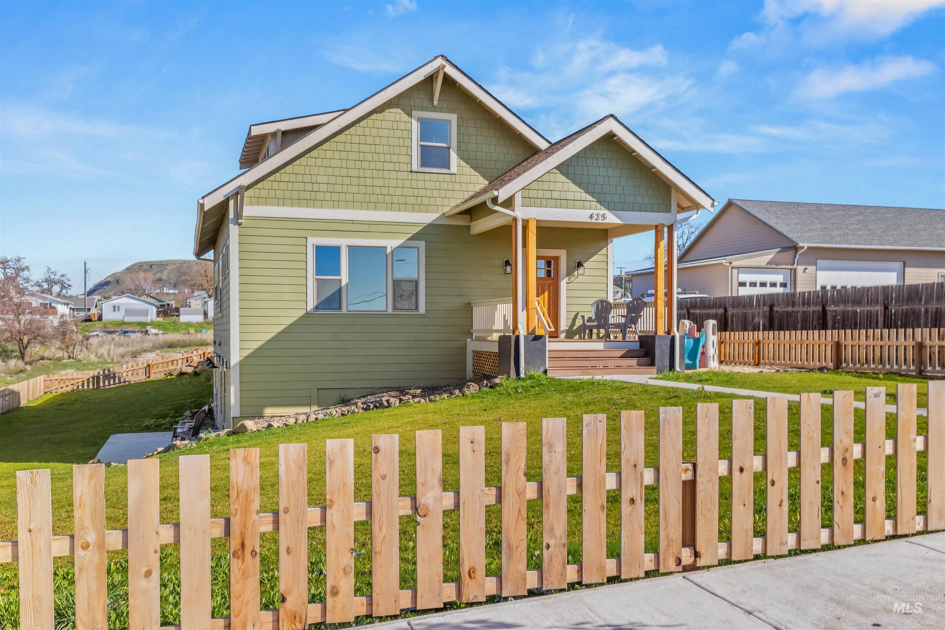 View of front facade with a deck with mountain view and a patio