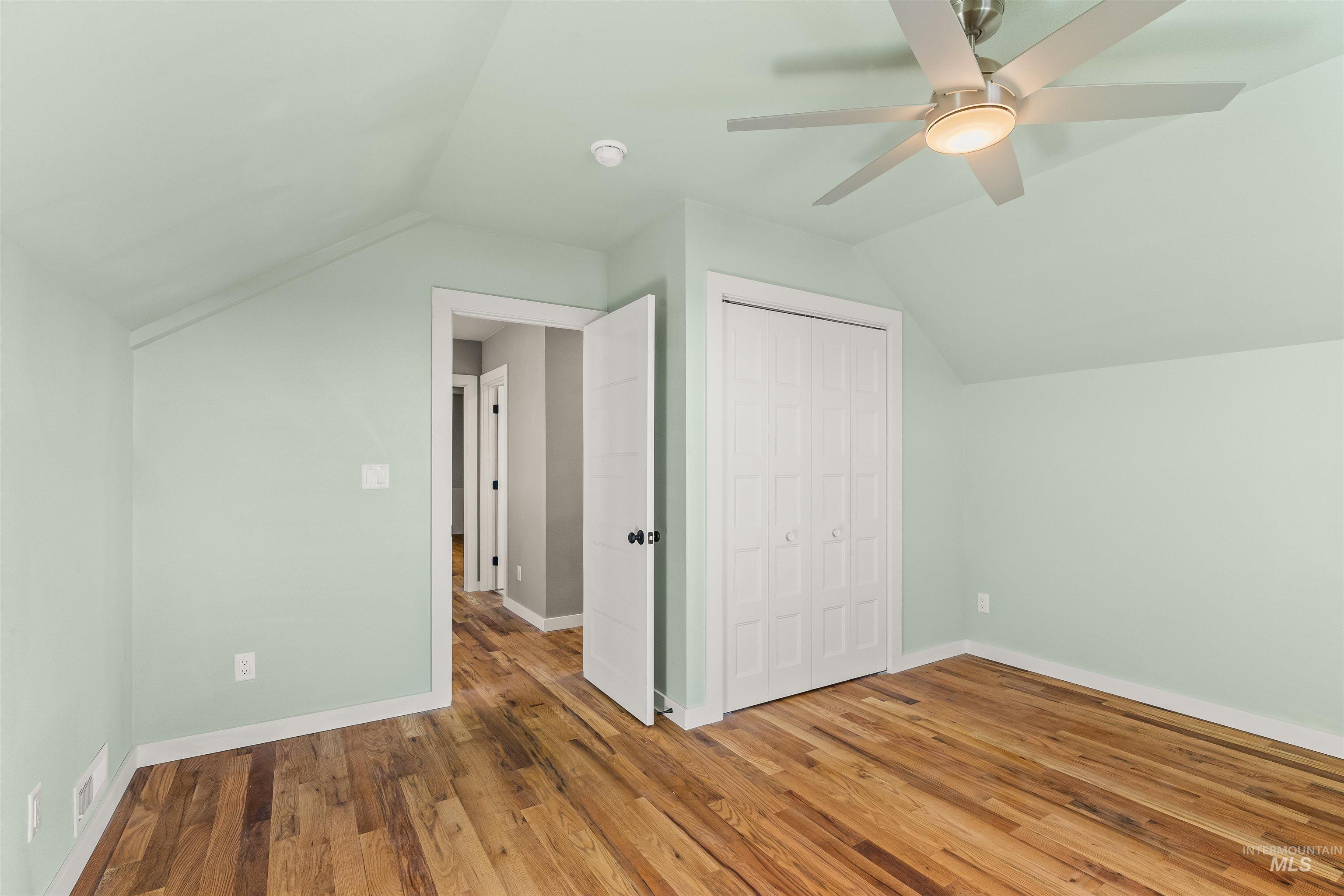 Bonus room with hardwood / wood-style flooring and a ceiling fan