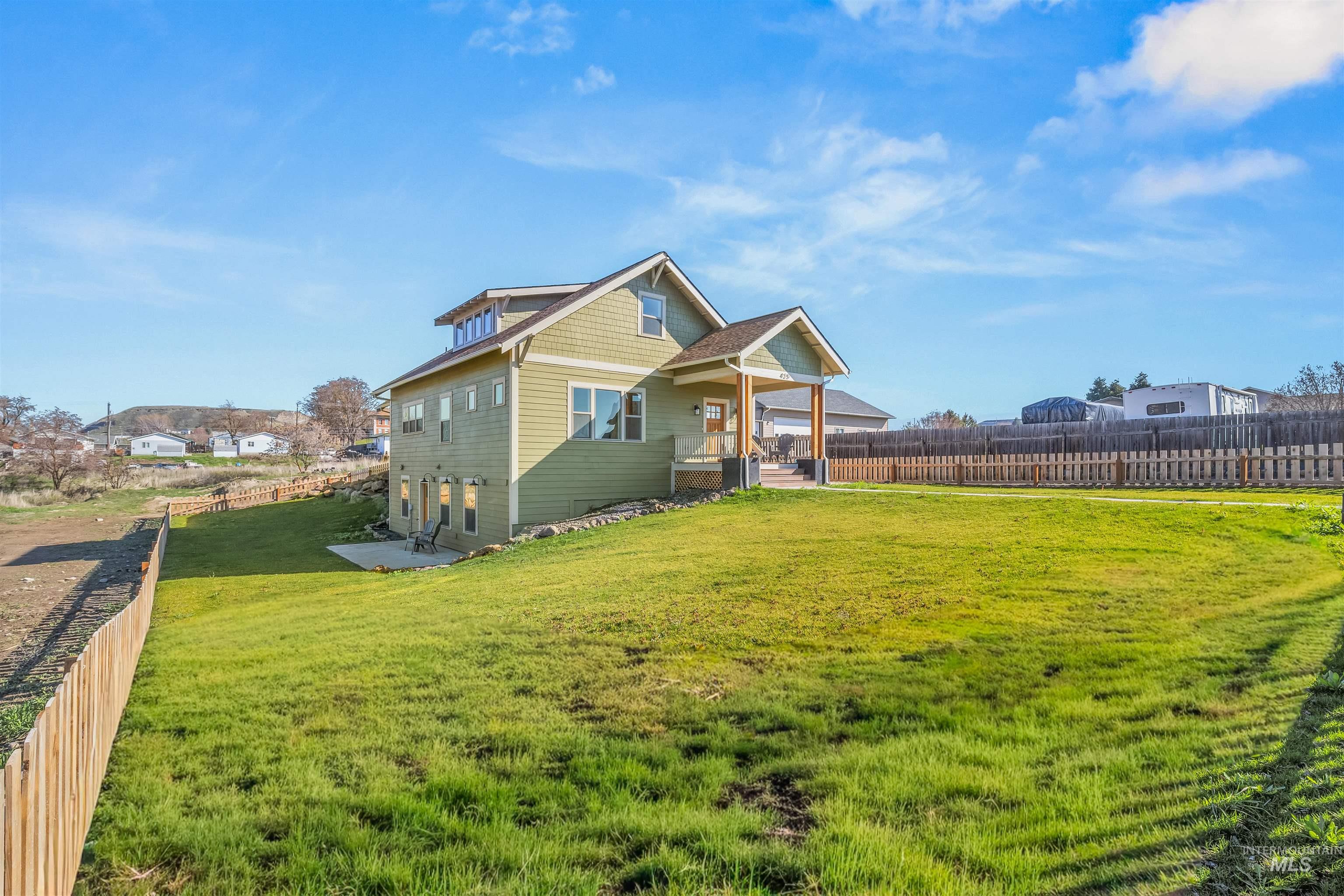 View of front facade featuring a fenced backyard, a patio, and a residential view