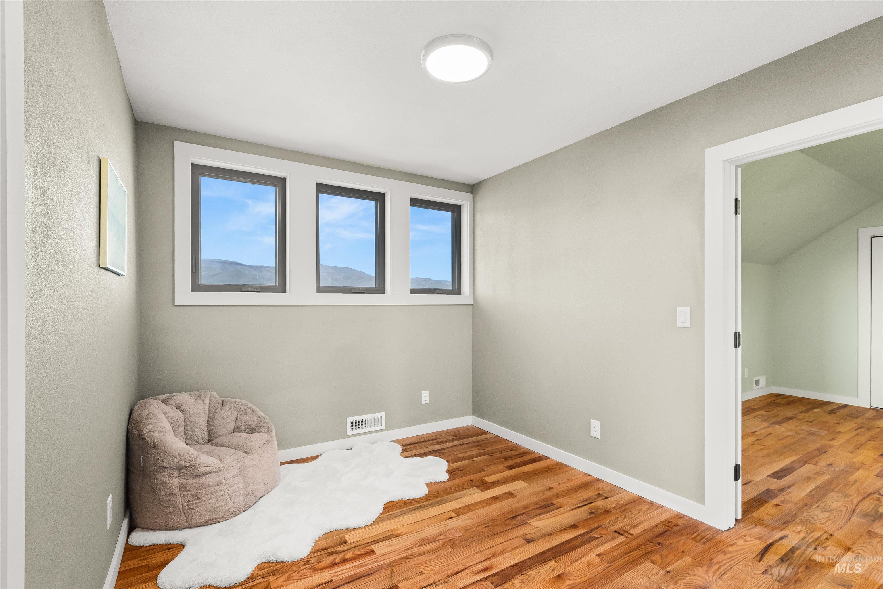 Sitting room featuring light wood-style floors and baseboards