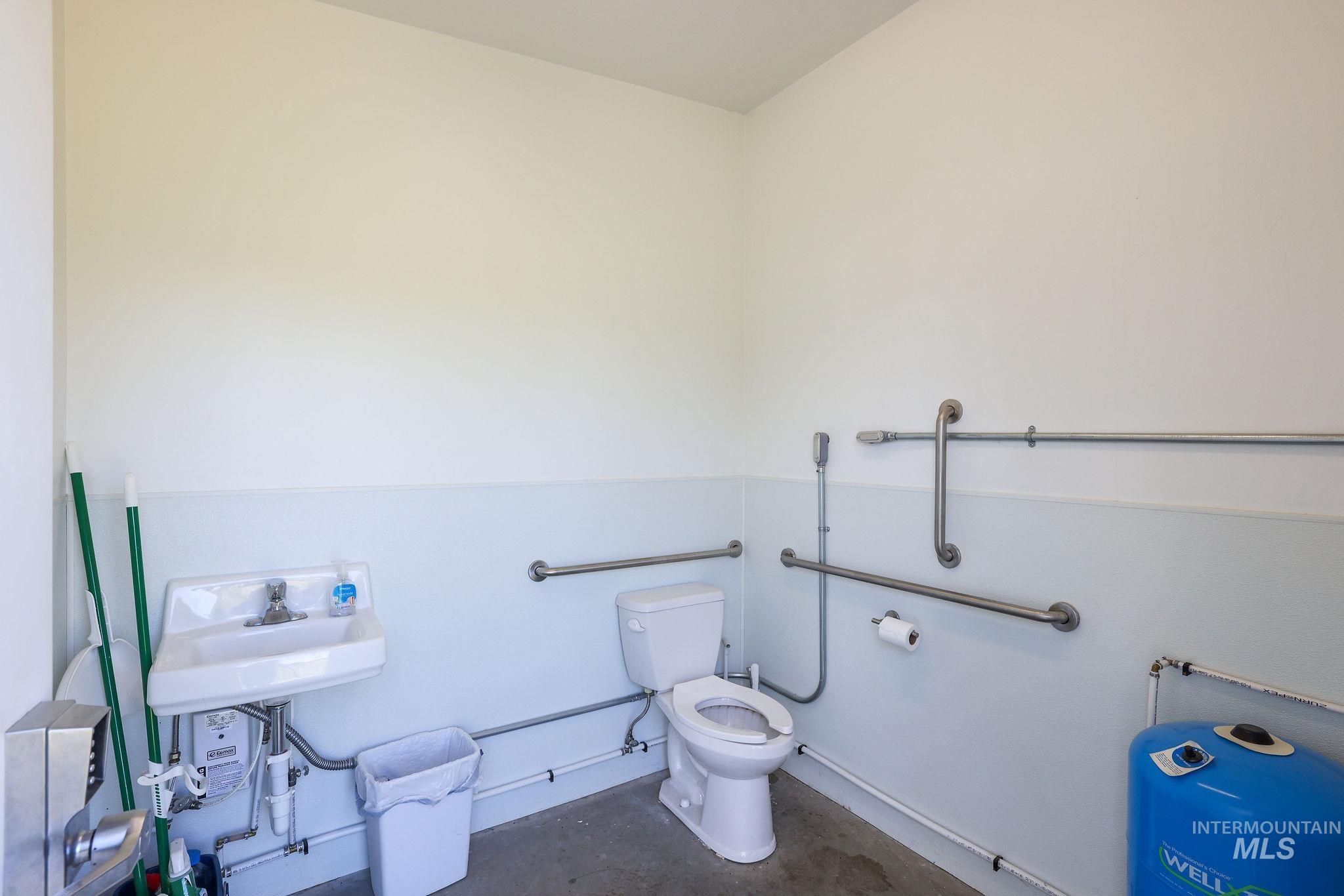 Half bath featuring toilet and concrete flooring