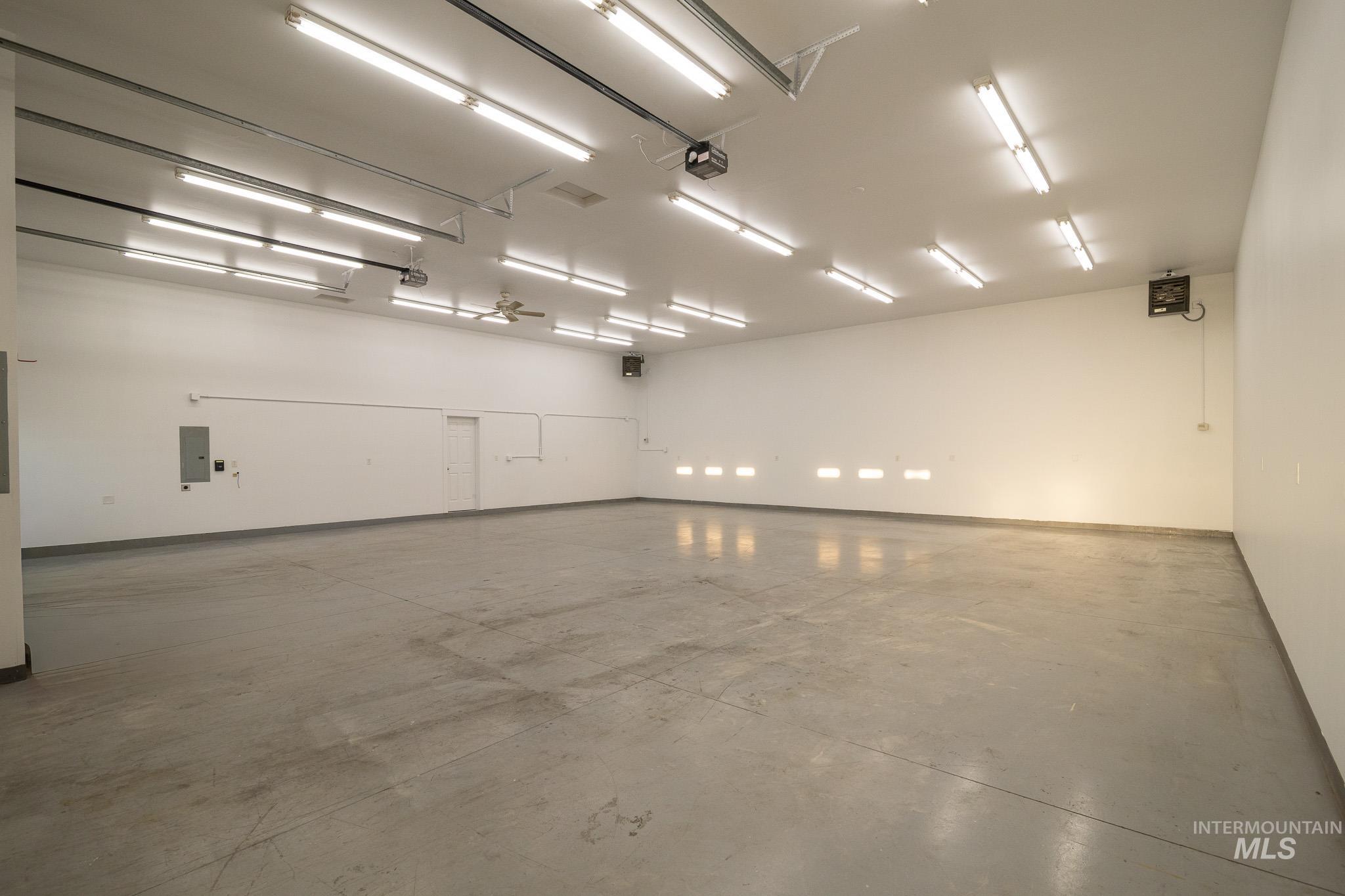 Garage with baseboards and electric panel