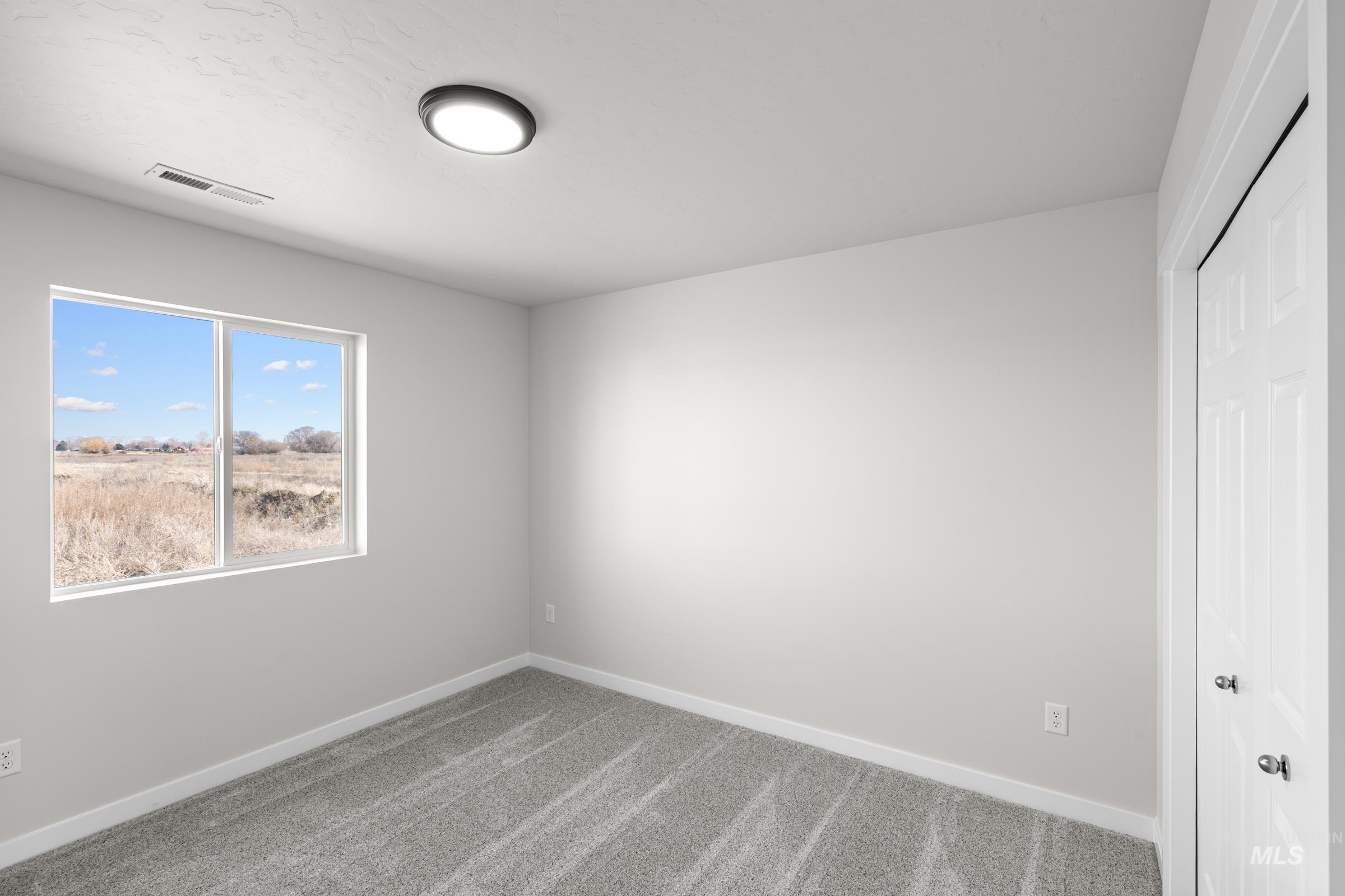 Empty room with light carpet and baseboards