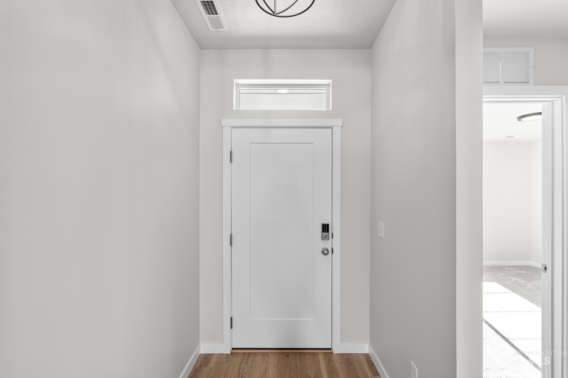 Doorway with baseboards and wood finished floors