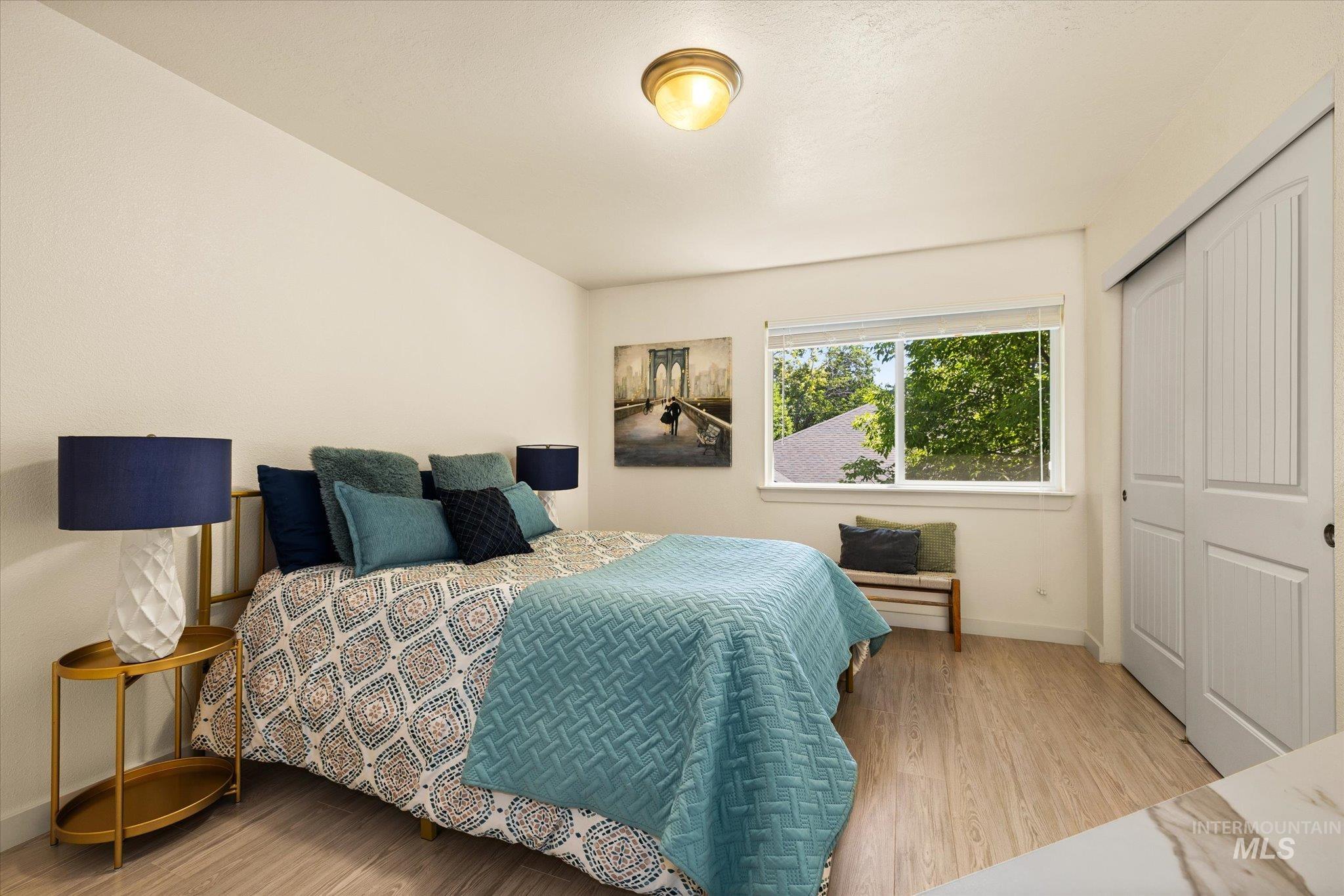 Bedroom with wood finished floors and a closet