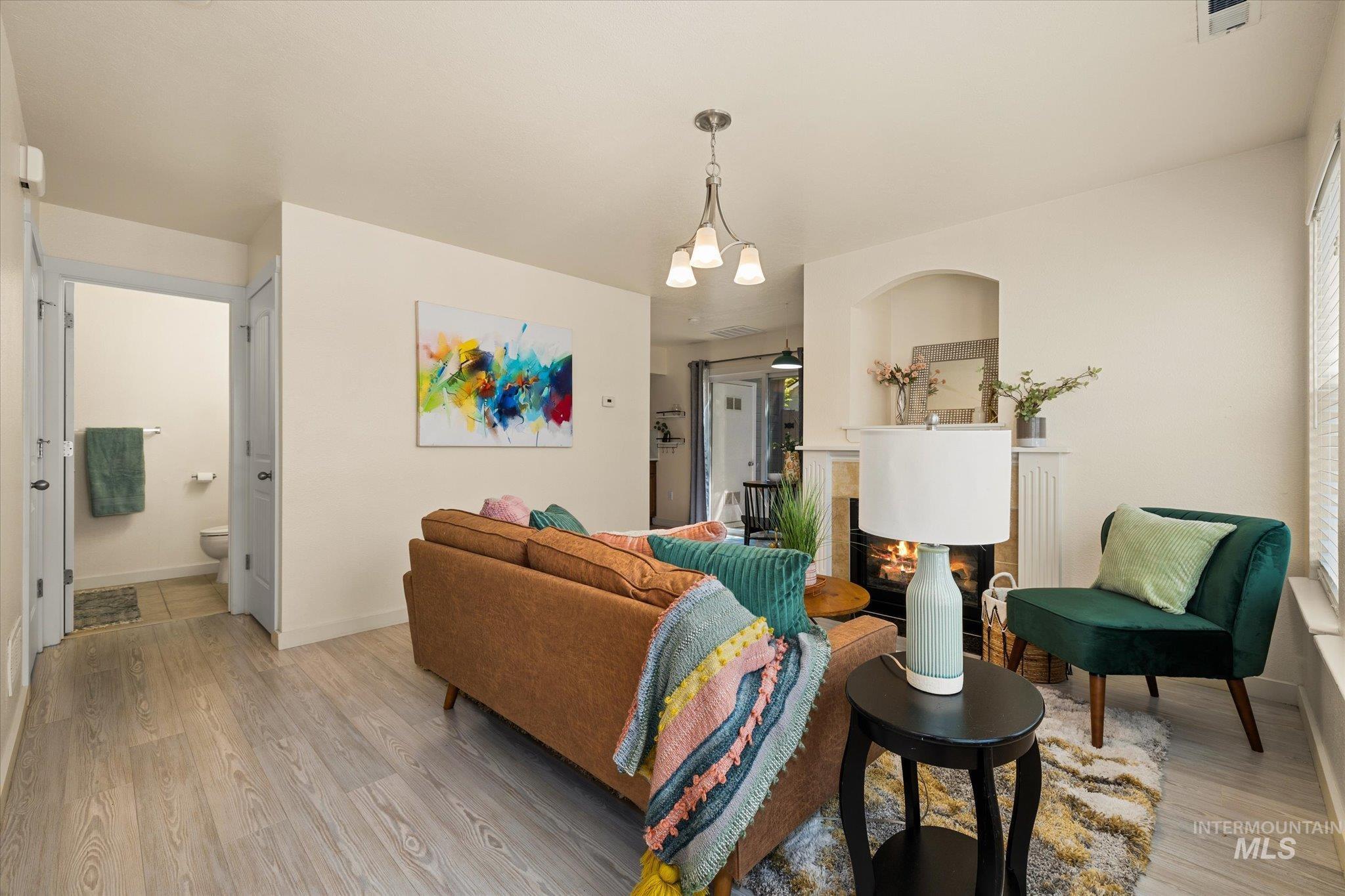 Living area featuring light wood finished floors and a glass covered fireplace