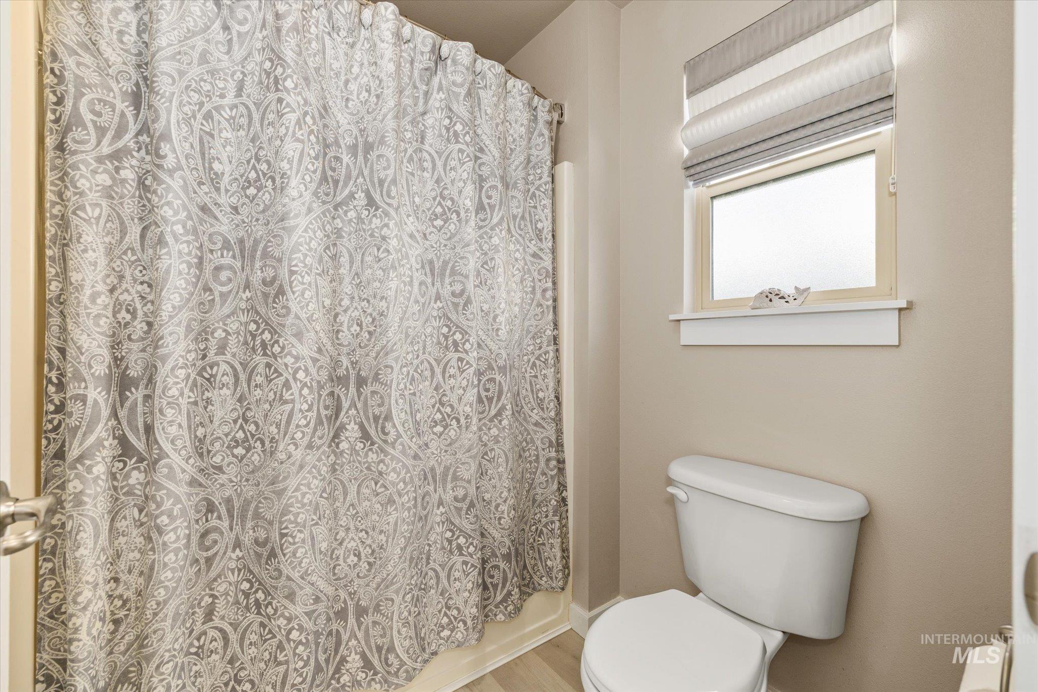 Full bathroom with toilet and baseboards