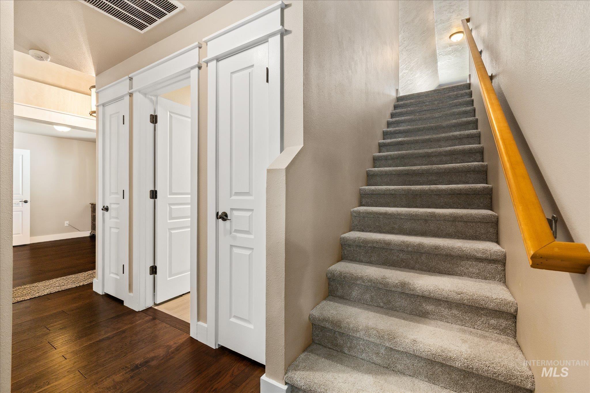 Stairway with hardwood / wood-style flooring and baseboards