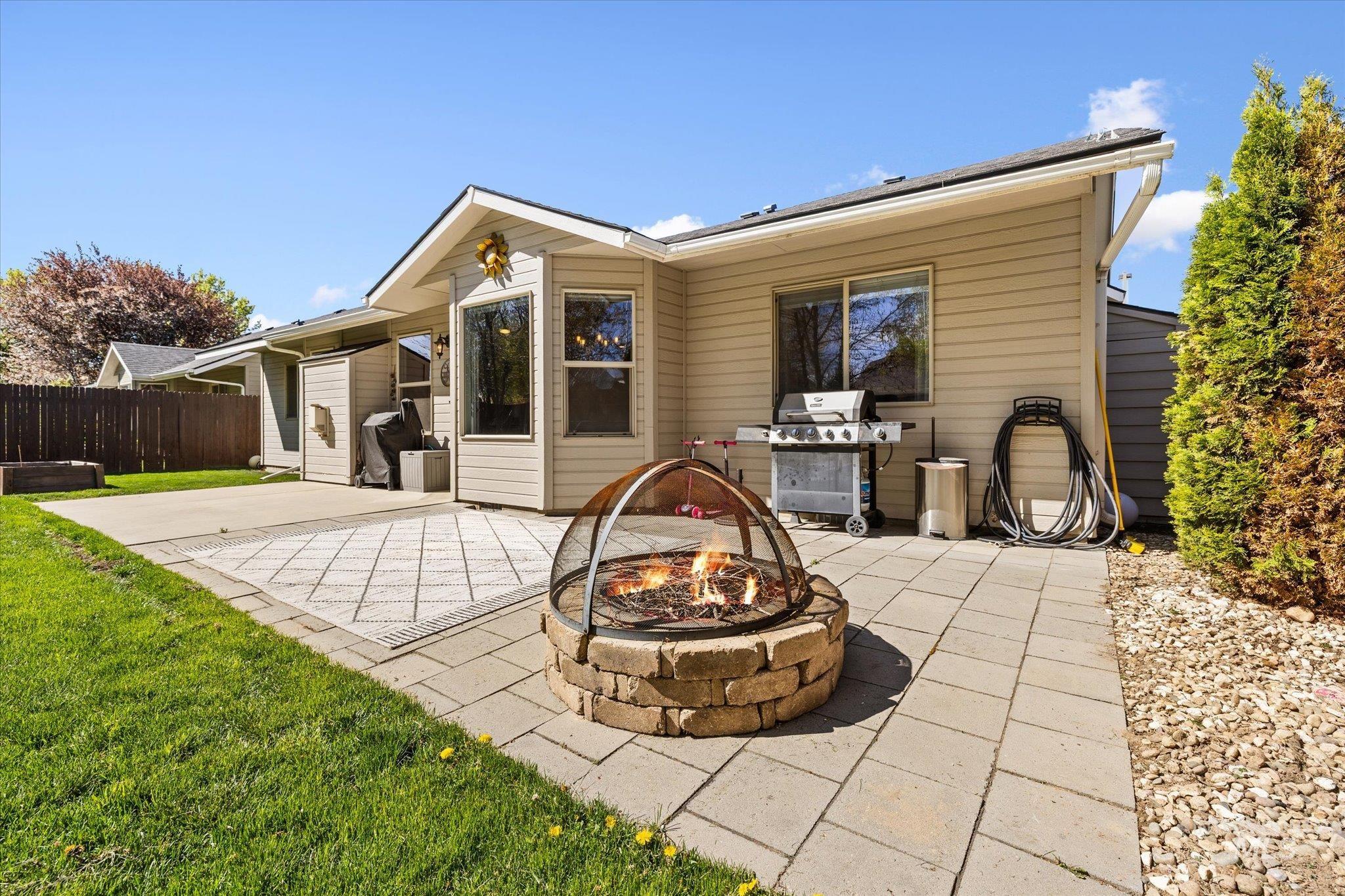 Rear view of house featuring a patio and an outdoor fire pit
