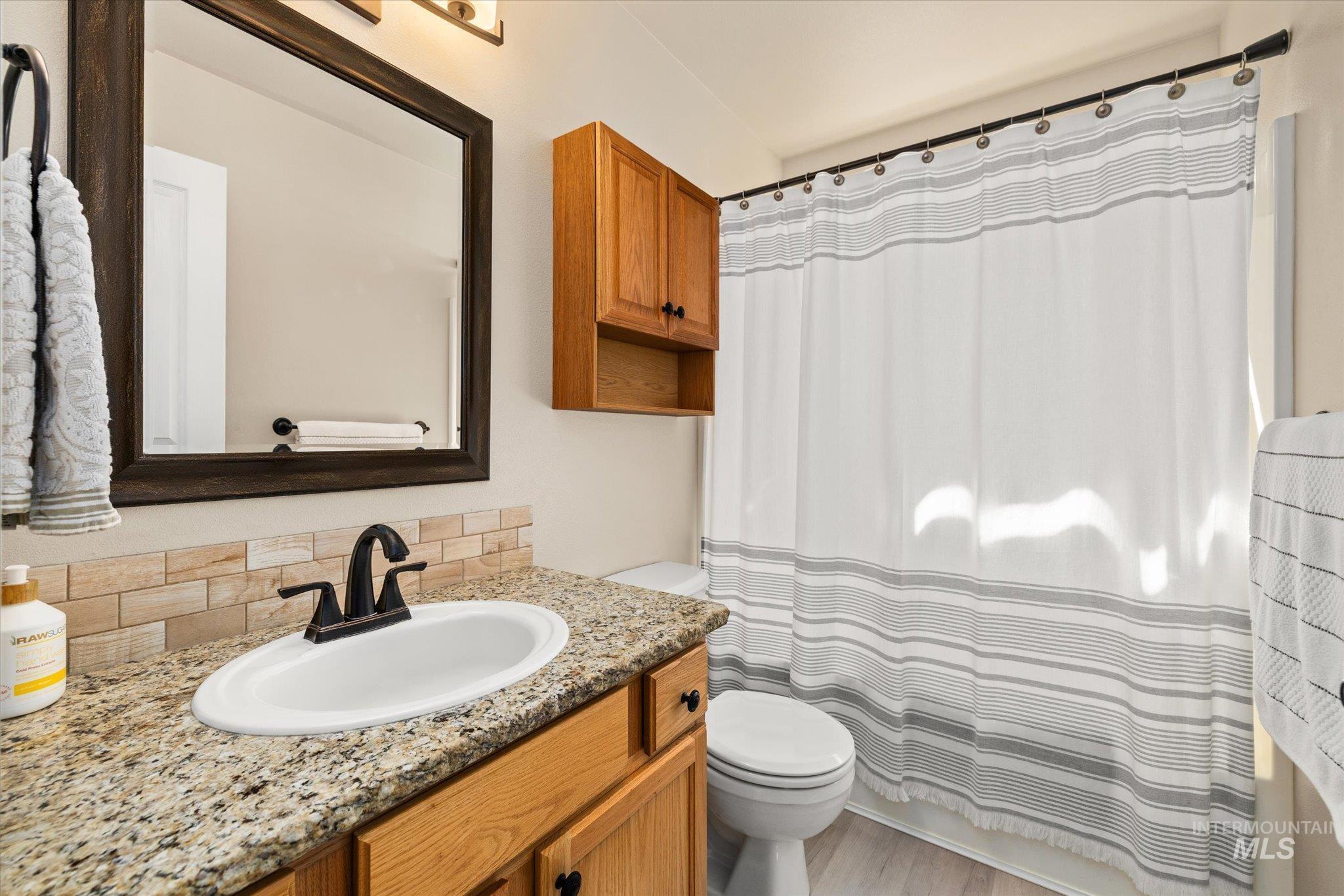 Full bathroom with vanity, light wood-style floors, and shower / bath combo