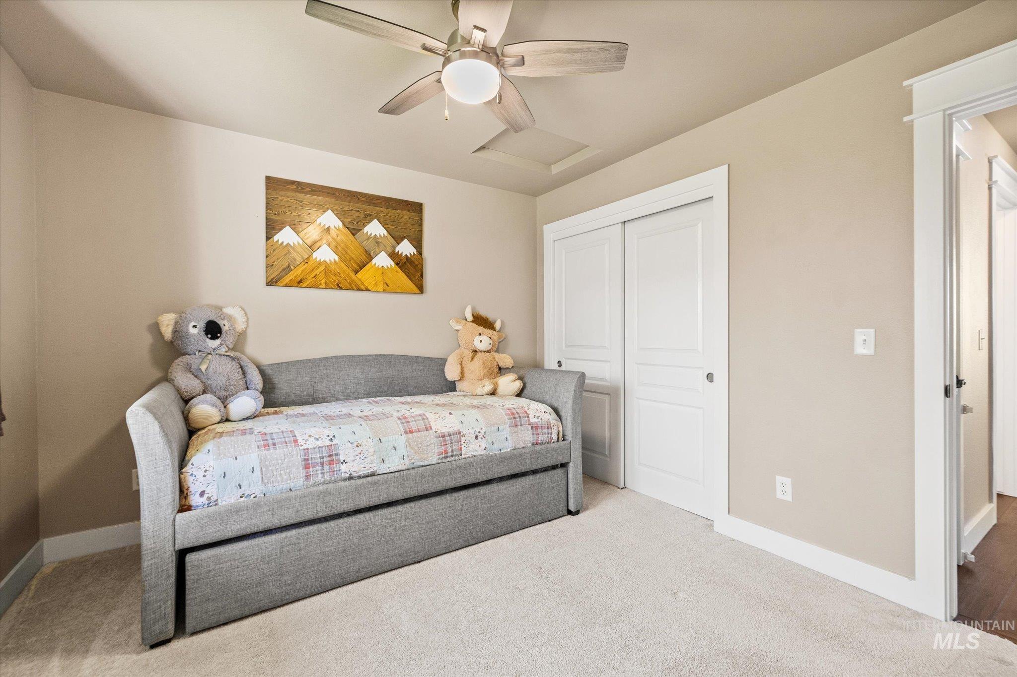 Carpeted bedroom featuring a closet and a ceiling fan