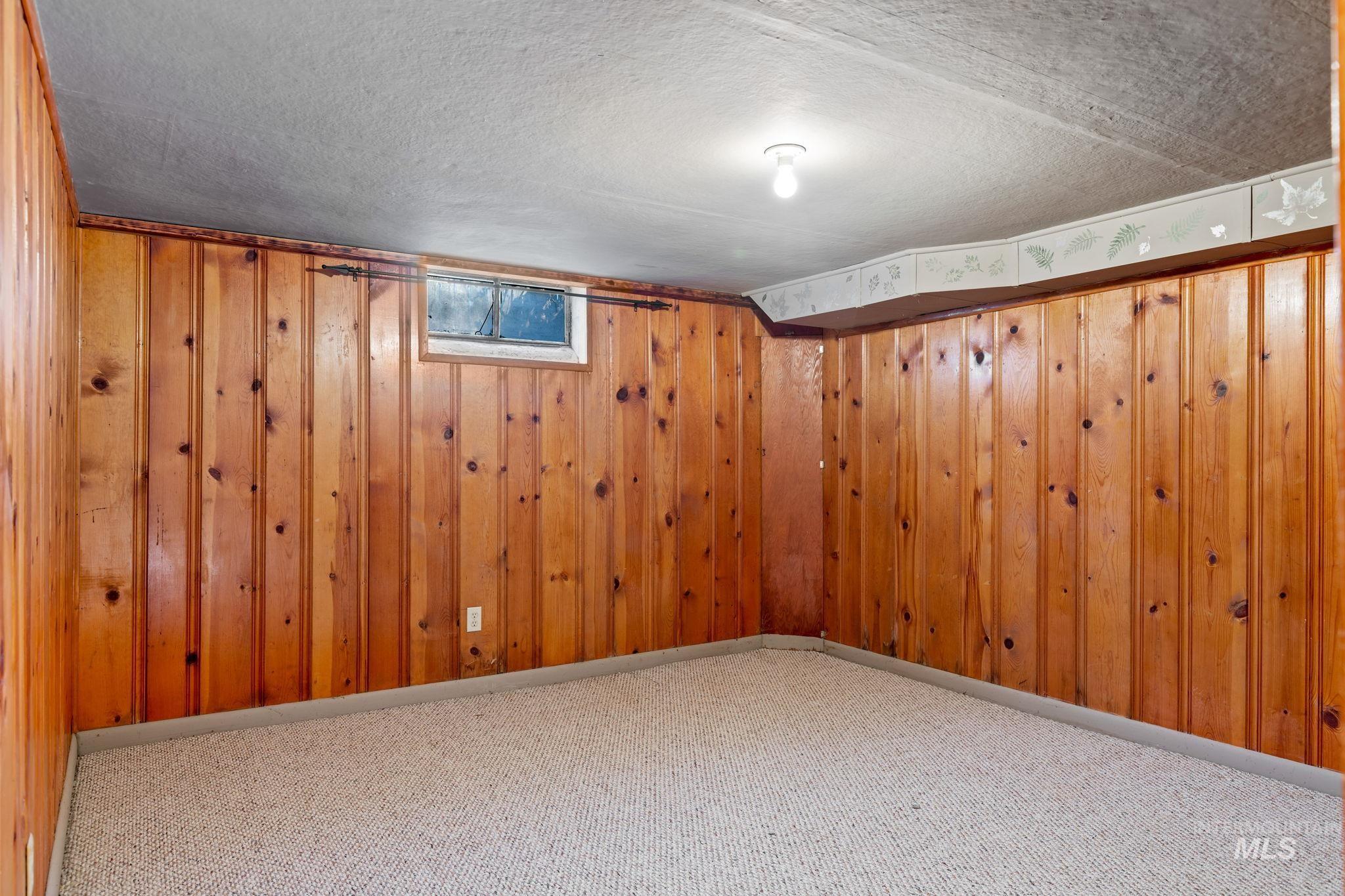 Finished below grade area with a textured ceiling and carpet floors
