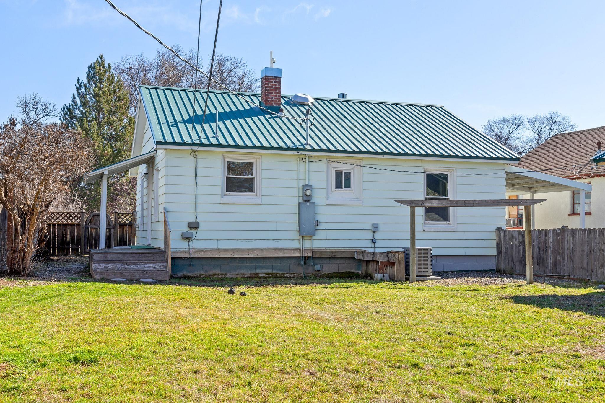 Rear view of house with a chimney and a metal roof