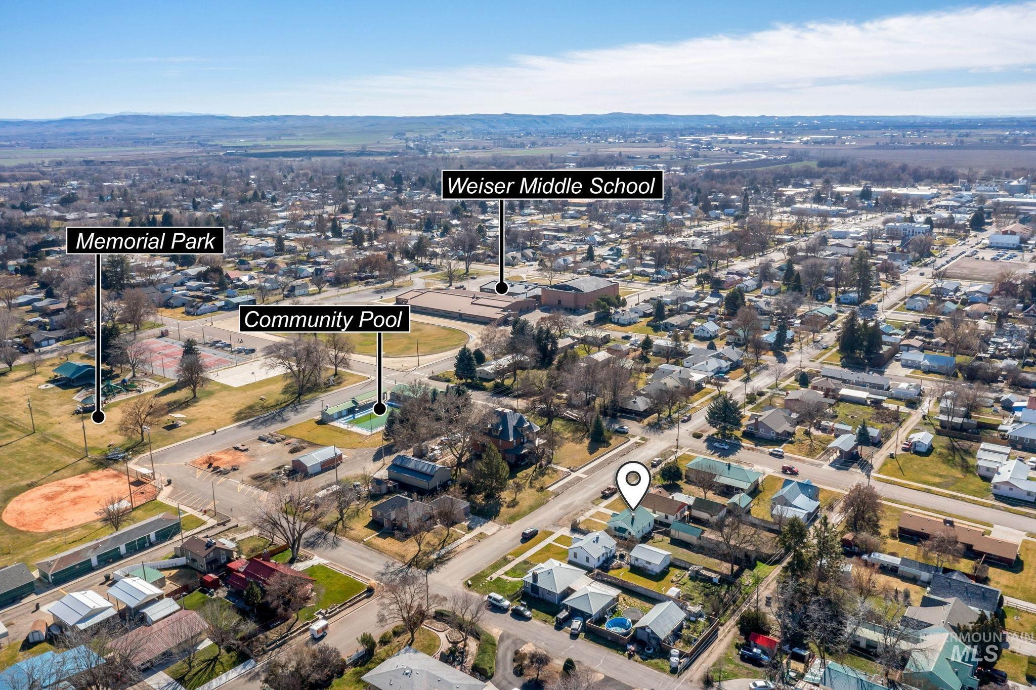 Aerial view of property and surrounding area with nearby suburban area