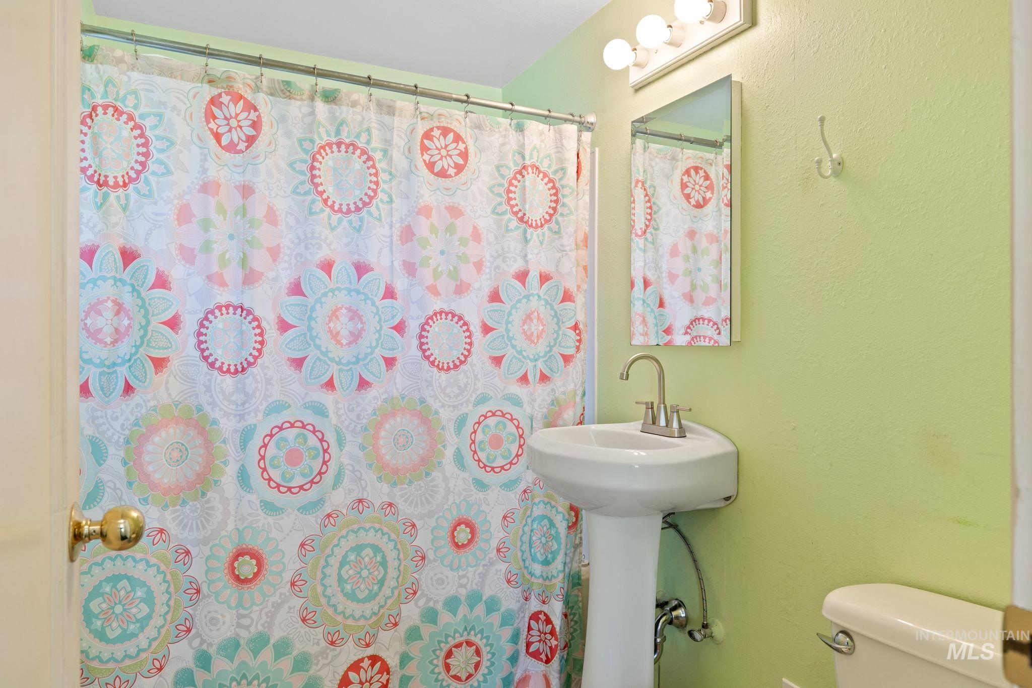 Full bathroom with a textured wall and a shower with curtain