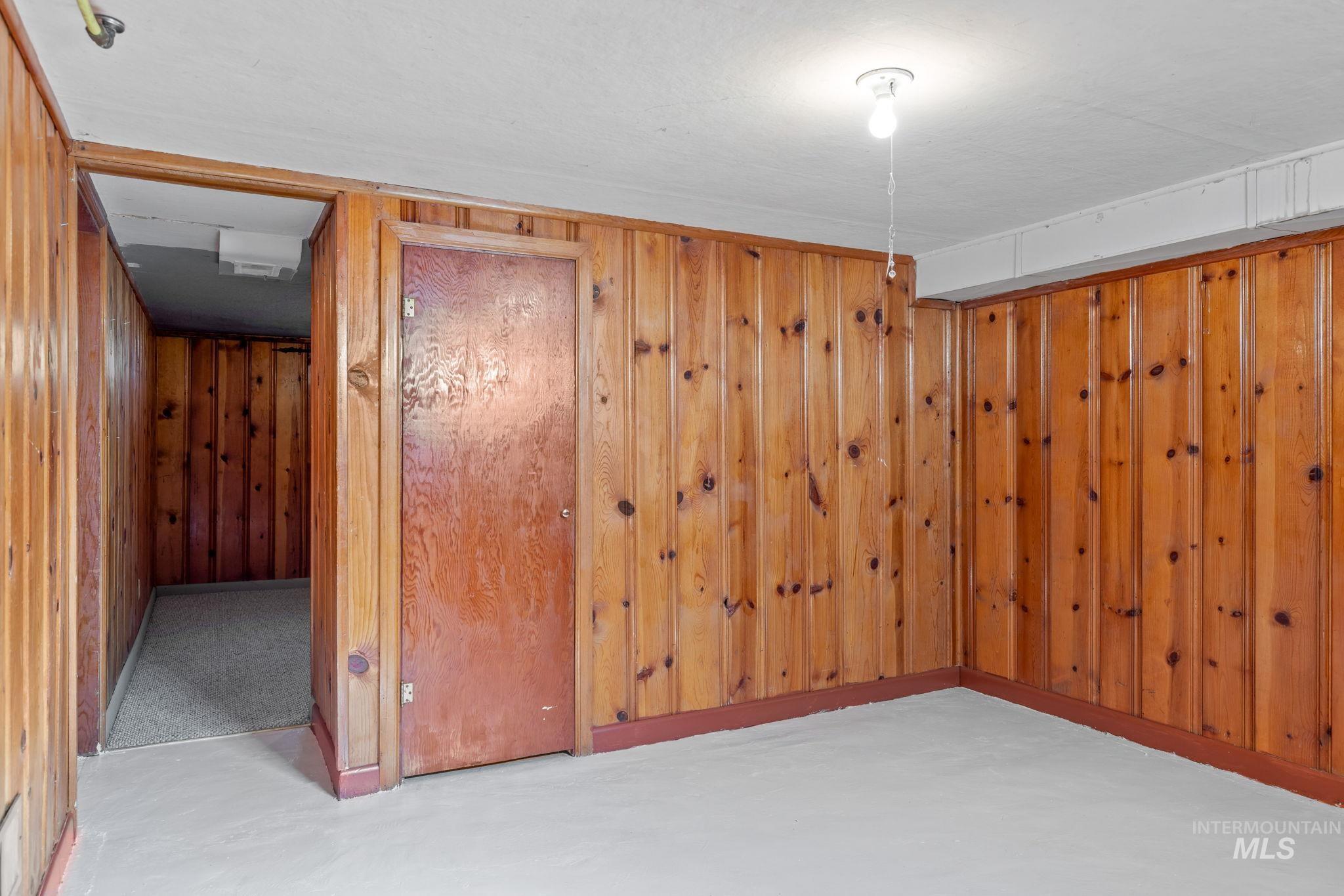 Finished basement featuring wooden walls and baseboards