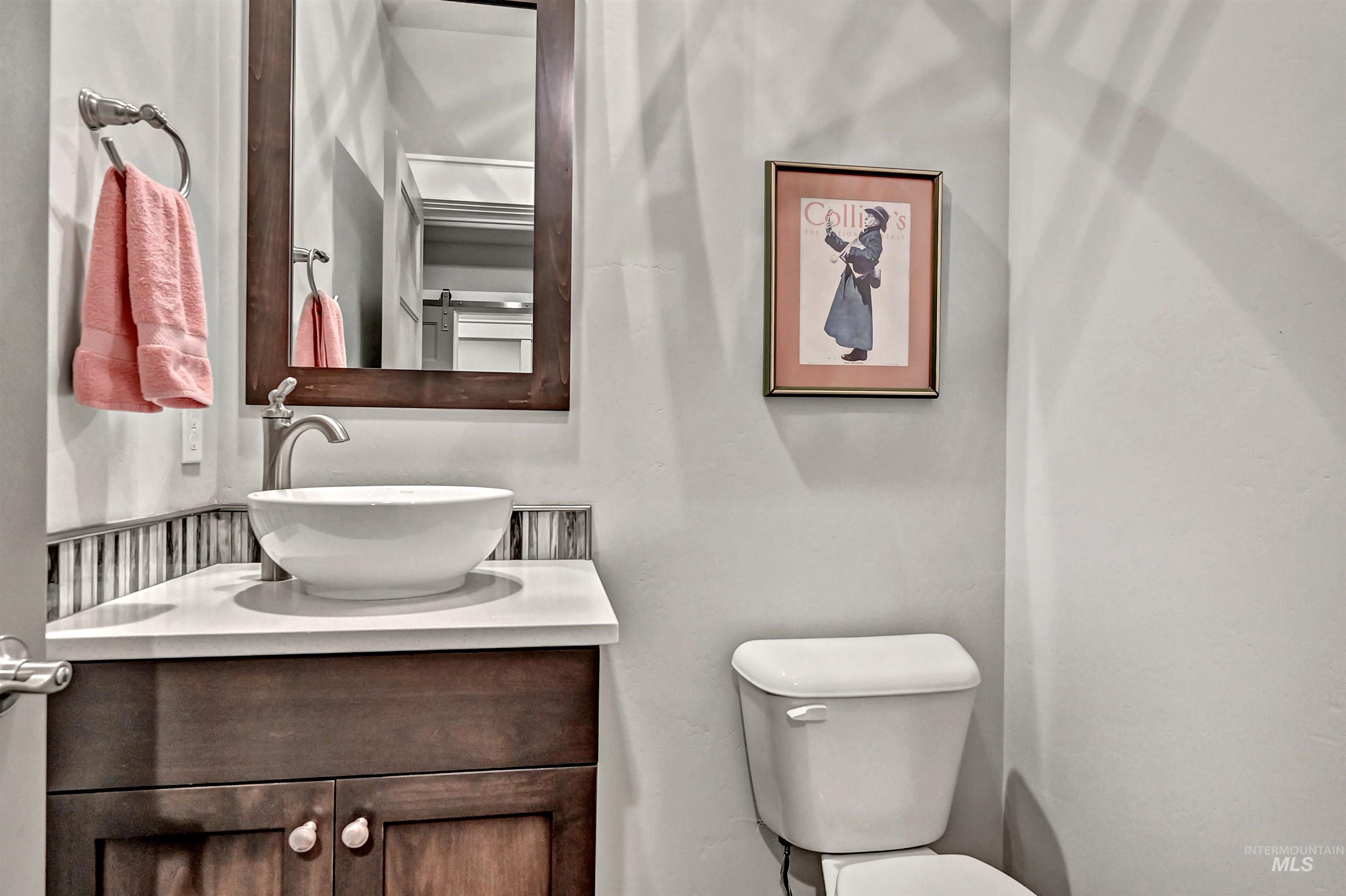 Half bathroom featuring vanity, sink, and toilet