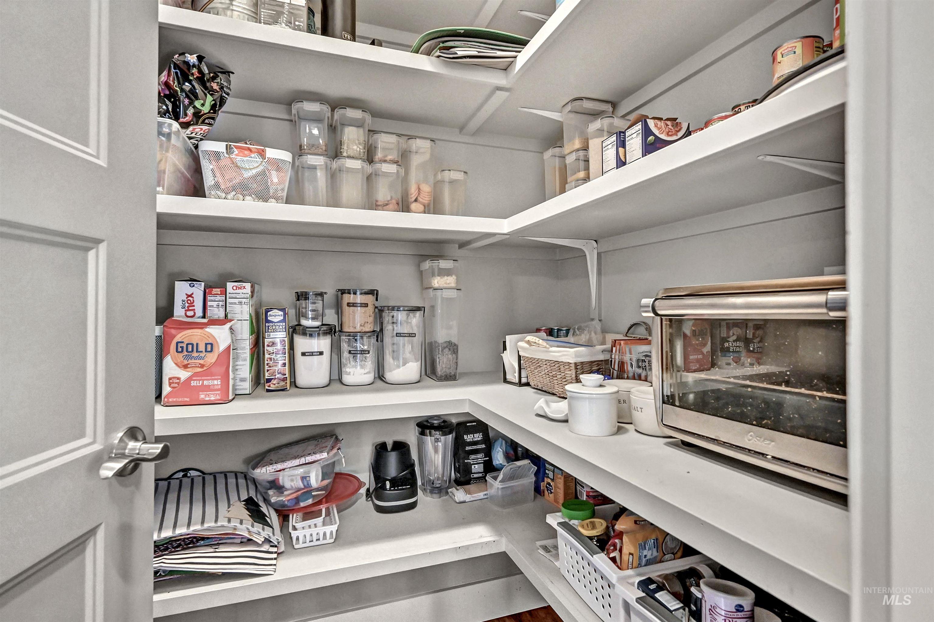 Large pantry with multiple shelves and a door
