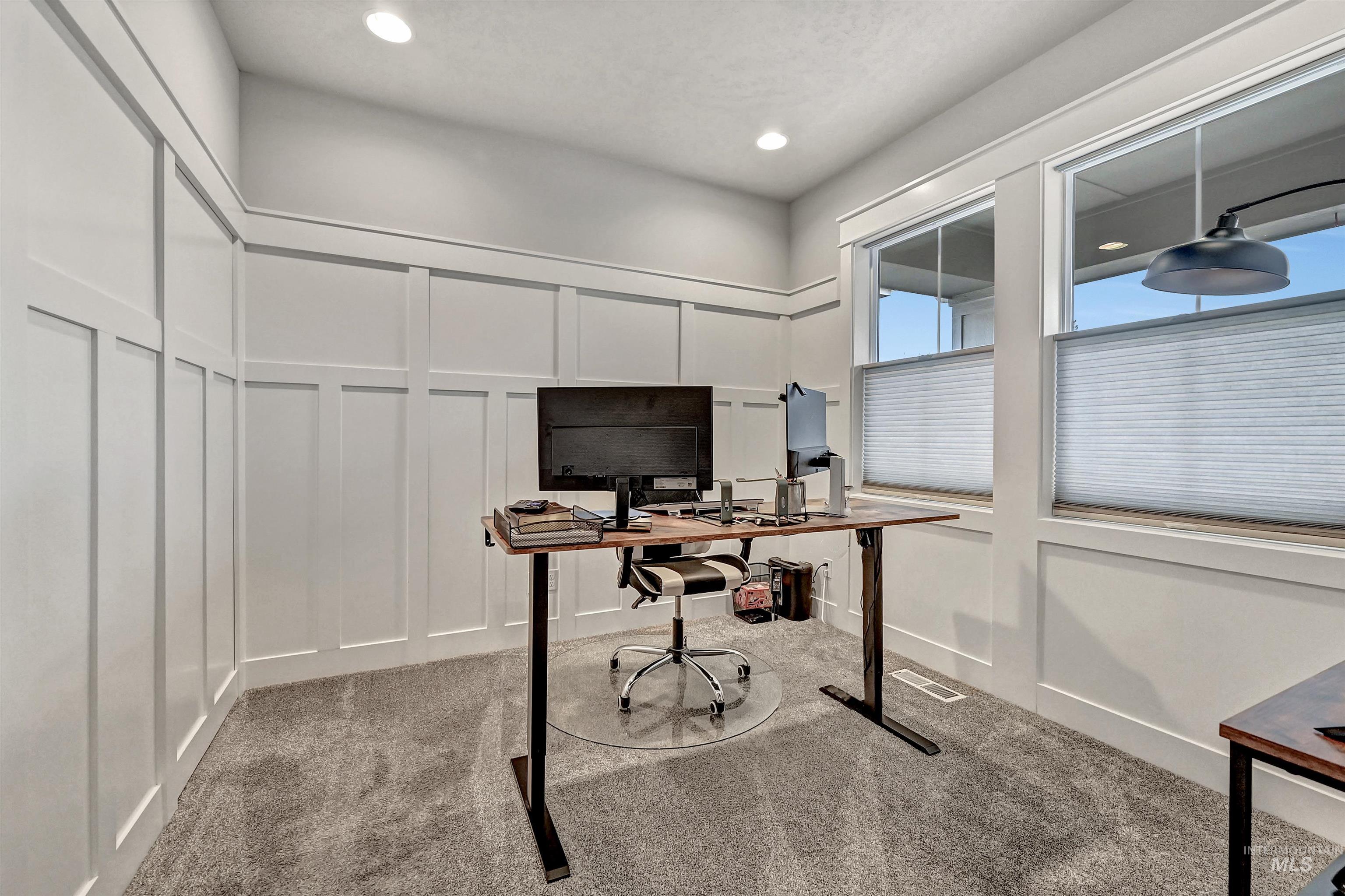 Carpeted office featuring painted-wood decorated walls & a large window