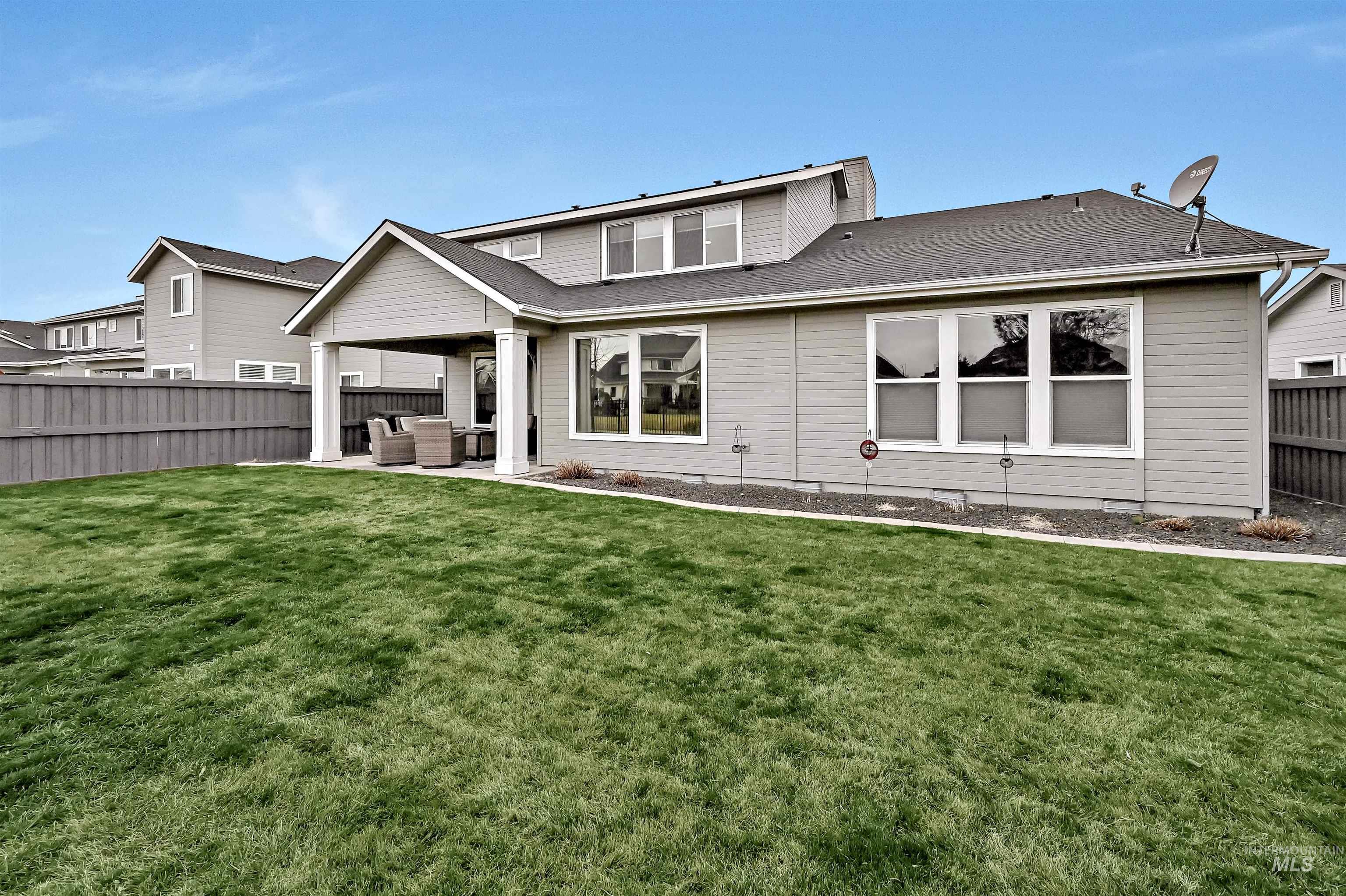 Rear view of house featuring a fenced backyard, a patio, and a shingled roof