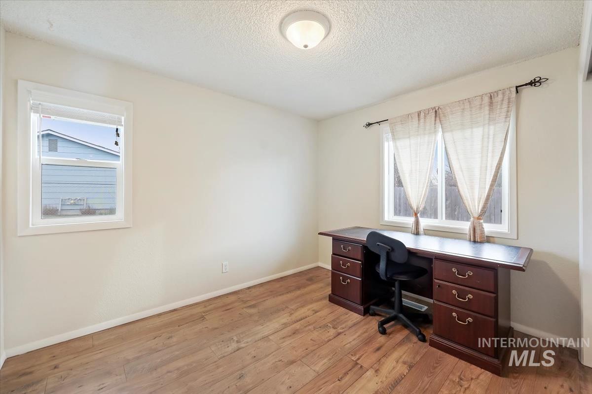 Office space with a textured ceiling and light wood finished floors
