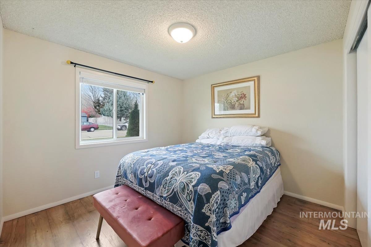 Bedroom with a textured ceiling and hardwood / wood-style flooring
