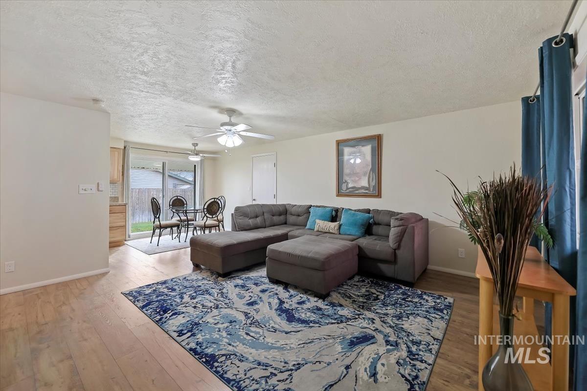 Living area featuring a textured ceiling, hardwood / wood-style flooring, and ceiling fan