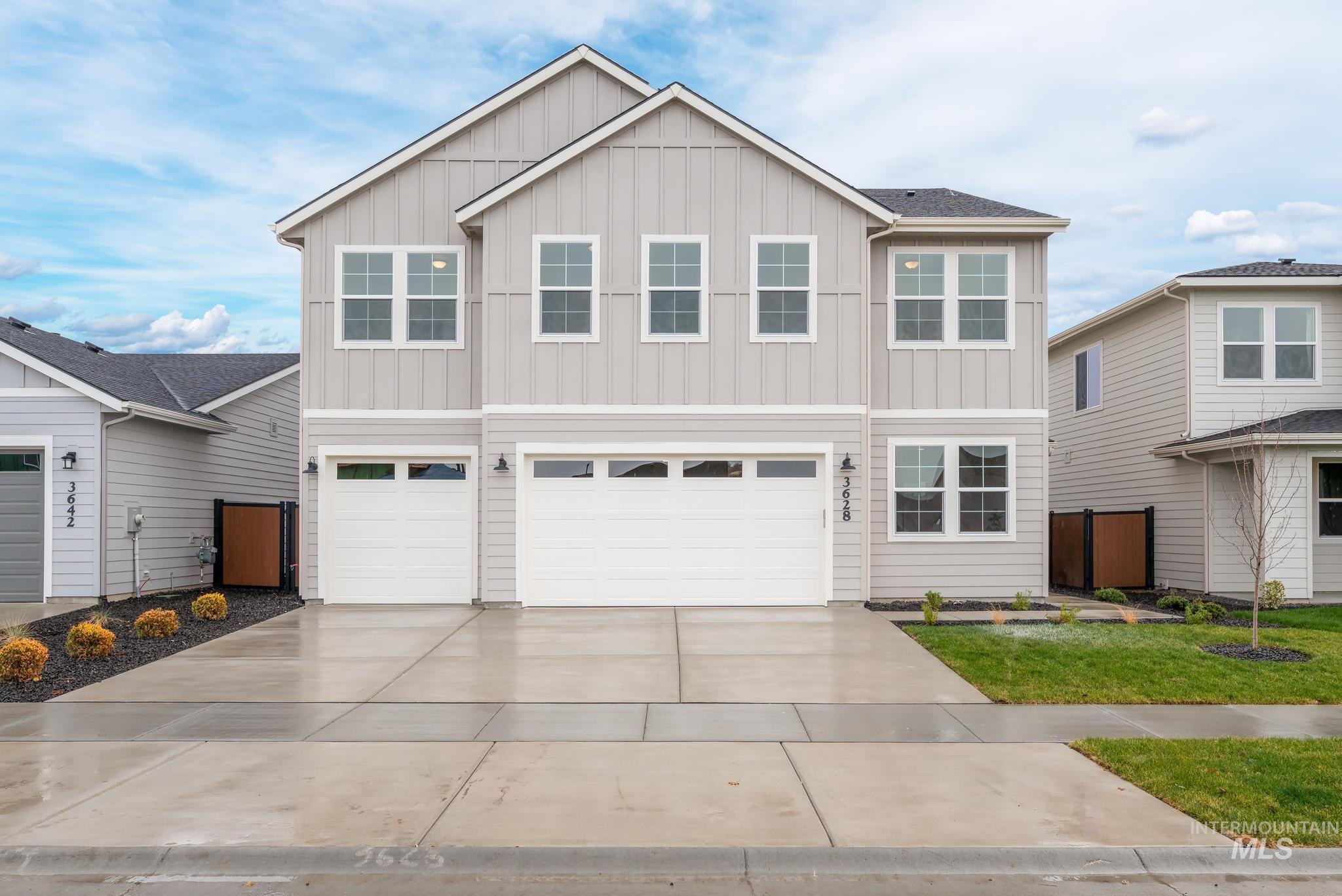 View of front of property featuring board and batten siding, a garage, and concrete driveway