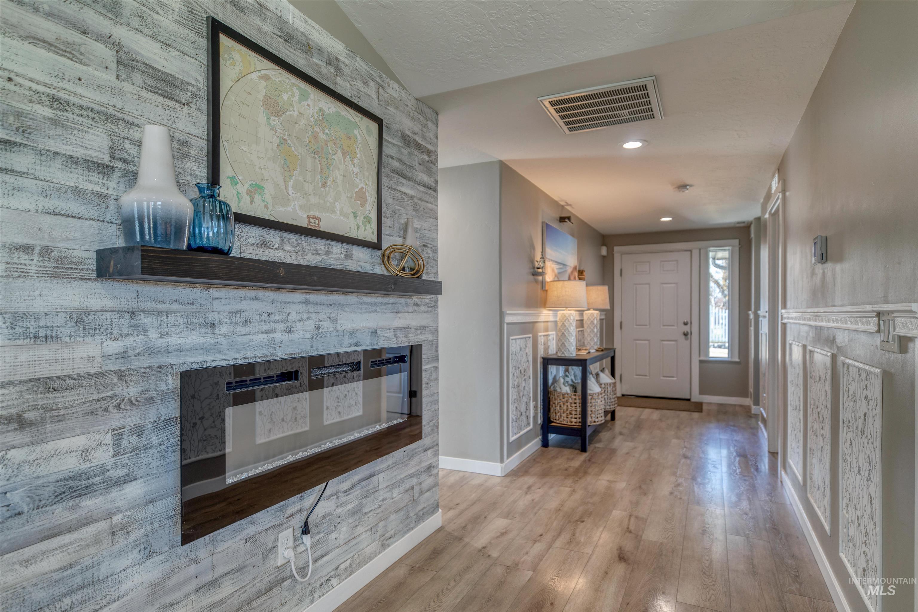 Foyer entrance featuring light wood-style flooring and a fireplace