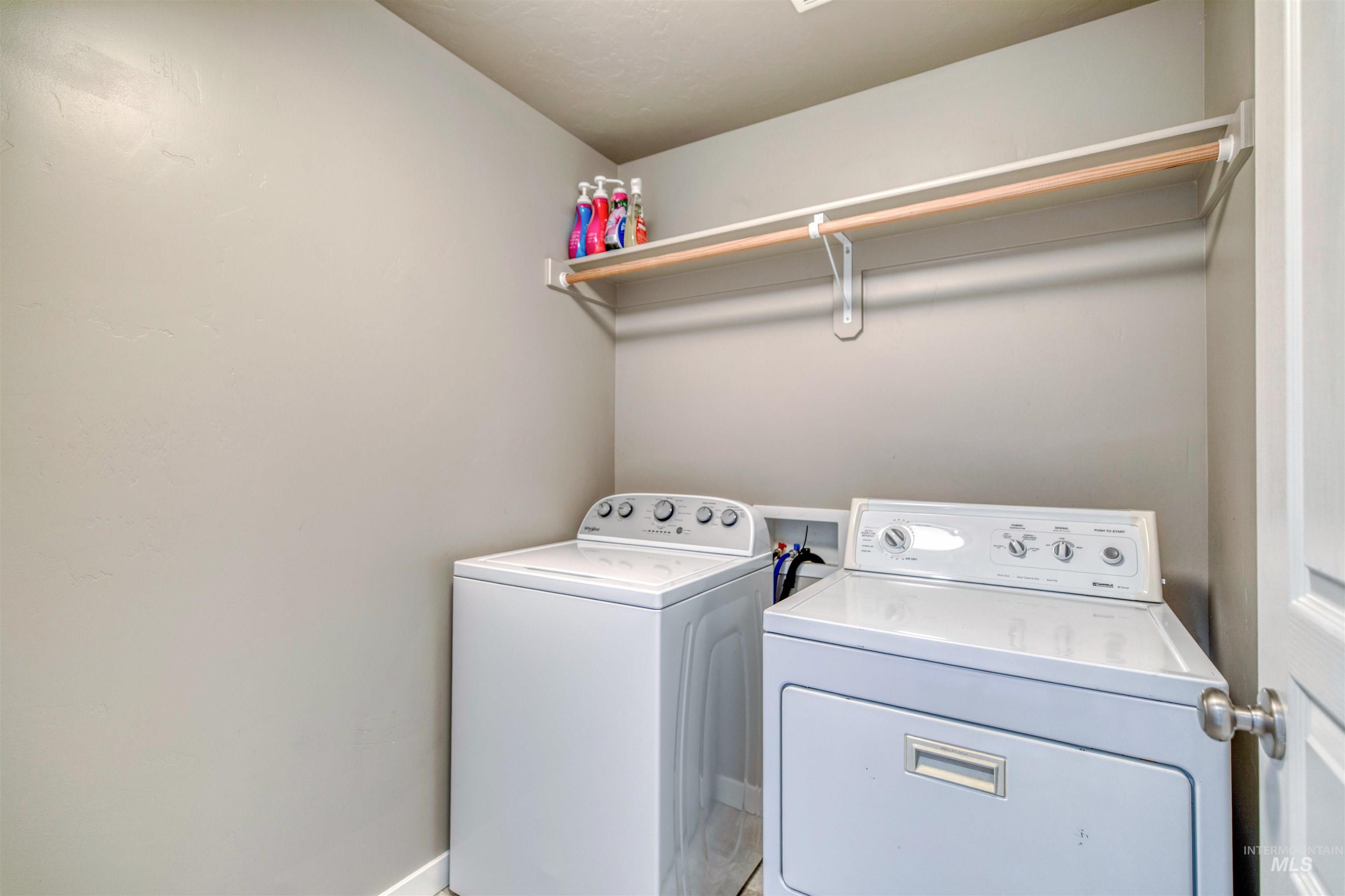 Laundry area featuring separate washer and dryer and baseboards